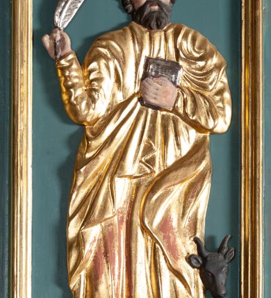 Zdjęcie nr 6: Ambona przyścienna, wisząca, z dostępem od zakrystii. Kosz na planie czterech boków z sześcioboku, na cokole w formie spłaszczonego wałka, z podwieszonym niewielkim cokolikiem zakończonym szyszką. Ścianki wydzielone pilastrami o kanelowanych trzonach, na cokołach, dźwigającymi parapet w formie gzymsu, wyłamany na ich osi. W polach ścianek płyciny o kształcie stojącego prostokąta z płaskorzeźbionymi przedstawieniami czterech ewangelistów. Zaplecek w formie wydłużonego, stojącego prostokąta, ujętego pilastrami o kanelowanych trzonach, zakończonych konsolami dekorowanymi liściem akantu, dźwigającymi imposty oraz przerwany, półokrągły przyczółek. W polu zaplecka drzwiczki do zakrystii, zdobione dwiema arkadami; ponad nimi płaskorzeźbione tablice praw. Baldachim na planie analogicznym względem kosza, w formie kopułki na wklęsłym, zwężającym się cokole dekorowanym płycinami, zakończonej latarnią z krzyżem na kuli. Brzeg w postaci gzymsu wyłamanego na osi podpór kosza, z siedzącymi nań puttami oraz z podwieszonym lambrekinem. Na podniebiu baldachimu rzeźbiona gołębica Ducha Świętego w glorii promienistej. 
Struktura polichromowana w kolorze szaro-niebieskim, profile i ornamentyka złocone.