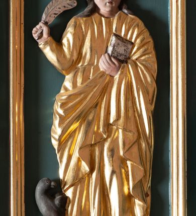 Zdjęcie nr 7: Ambona przyścienna, wisząca, z dostępem od zakrystii. Kosz na planie czterech boków z sześcioboku, na cokole w formie spłaszczonego wałka, z podwieszonym niewielkim cokolikiem zakończonym szyszką. Ścianki wydzielone pilastrami o kanelowanych trzonach, na cokołach, dźwigającymi parapet w formie gzymsu, wyłamany na ich osi. W polach ścianek płyciny o kształcie stojącego prostokąta z płaskorzeźbionymi przedstawieniami czterech ewangelistów. Zaplecek w formie wydłużonego, stojącego prostokąta, ujętego pilastrami o kanelowanych trzonach, zakończonych konsolami dekorowanymi liściem akantu, dźwigającymi imposty oraz przerwany, półokrągły przyczółek. W polu zaplecka drzwiczki do zakrystii, zdobione dwiema arkadami; ponad nimi płaskorzeźbione tablice praw. Baldachim na planie analogicznym względem kosza, w formie kopułki na wklęsłym, zwężającym się cokole dekorowanym płycinami, zakończonej latarnią z krzyżem na kuli. Brzeg w postaci gzymsu wyłamanego na osi podpór kosza, z siedzącymi nań puttami oraz z podwieszonym lambrekinem. Na podniebiu baldachimu rzeźbiona gołębica Ducha Świętego w glorii promienistej. 
Struktura polichromowana w kolorze szaro-niebieskim, profile i ornamentyka złocone.