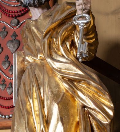 Zdjęcie nr 12: Ołtarz architektoniczny, jednokondygnacyjny, jednoosiowy, z bramkami i zwieńczeniem. Ołtarz kamienny, sarkofagowy, wklęsło-wypukły, na cokole. Mensa kamienna, o brzegu w formie profilowanego gzymsu. Tabernakulum drewniane, obite blachą, w postaci prostopadłościennej skrzynki, z wypukłą ścianką frontową, flankowane parą drewnianych kolumienek o kapitelach kompozytowych, na cokołach. Drzwiczki w formie kwadratu zamkniętego łukiem półkolistym, ujęte ramą z odlewaną dekoracją roślinną, w polu aplikowane, odlewane przedstawienie kielicha eucharystycznego w glorii promienistej na obłoku, z kłosami zbóż po bokach. Na tabernakulum osadzony tron wystawienia w formie prostopadłościanu, z wypukłą ścianką frontową oraz obrotową niszą ujętą profilowaną ramą, flankowany parą kolumienek o kapitelach kompozytowych, dźwigających imposty oraz przerwane w partii architrawu i fryzu belkowanie opasujące go z trzech stron. Na osi podpór przerwany, segmentowy przyczółek, ustawiony pod kątem. Na belkowaniu figurka Baranka Apokaliptycznego, leżącego na księdze na tle glorii promienistej. 
Retabulum na dwustrefowym cokole, w górnej partii zryzalitowanym przy brzegach, ujęte parą zwielokrotnionych pilastrów oraz stojącą przed nimi parą kolumn o kapitelach kompozytowych, ustawionych pod katem względem lica. Podpory dźwigają pełne belkowanie, wyłamane na ich osi, przerwane nad polem środkowym; na linii kolumn przerwany półokrągły przyczółek. W polu zwieńczenia gloria promienista z rzeźbioną gołębicą Ducha Świętego w otoczeniu obłoków i uskrzydlonych główek anielskich. W polu środkowym nisza w formie stojącego prostokąta zamkniętego łukiem segmentowym, w profilowanej ramie, z obrazem Matki Boskiej z Dzieciątkiem w aediculi. Bramki z przejściami w formie wydłużonego, stojącego prostokąta o wklęsłych górnych narożach, zamknięte dwoma spływami wolutowymi stanowiącymi podstawę dla cokołów na figury św. Piotra i św. Pawła. 
Cokoły kolumn dekorowane akantem. W polu środkowym, nad niszą para puttów podtrzymujących koronę; ramę flankują rocaillowe zwisy; u jej spodu palmety i rozety. Na brzegach belkowania wazony dekorowane plecionką i liśćmi. Kondygnacja ujęta uszami utworzonymi z wolut i liści palmowych. Spód cokołu wieńczącego bramki dekorowany muszlą; woluty zdobione kampanulami.
 Struktura polichromowana w kolorze szaro-niebieskim; kolumny, ramy, gloria, profile i ornamentyka złocone; obłoki srebrzone.
