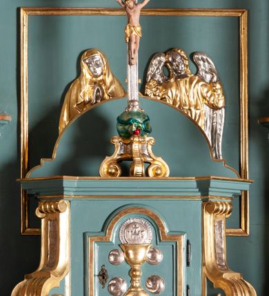 Zdjęcie nr 12: Ołtarz architektoniczny, jednokondygnacyjny, jednoosiowy, ze zwieńczeniem. Ołtarz sarkofagowy, z drewnianą mensą. Retabulum osadzone na wysokim, zdwojonym cokole o skośnie zryzalitowanych bokach. Część środkową ujmują zwielokrotnione pilastry oraz para kolumn. Podpory wspierają wyłamujące się ponad nimi belkowanie przerwane w partii architrawu i fryzu. Zwieńczenie ujęte parą spływów wolutowych, zamknięte fragmentem gzymsu w kształcie półkolistego łuku nadwieszonego, po bokach flankowane przerwanym, wolutowym przyczółkiem. Pola cokołów retabulum wypełnione stylizowaną ornamentyką roślinną, pośrodku płaskorzeźbiona scena Zwiastowania ujęta wąską, złoconą ramką. Kapitele kolumn i pilastrów zdobione motywami rozetek. Pośrodku belkowania kartusz o fantazyjnym wykroju. Szczyt zwieńczenia w formie promienistej glorii z ujętym wieńcem obłoków trójkątem w monogramem maryjnym. Na przerwanym przyczółku para aniołków. Pole części środkowej w kształcie stojącego prostokąta zamkniętego półkolistym łukiem nadwieszonym. W środku przedstawienie św. Antoniego Padewskiego, na zasuwie św. Józef. W polu zwieńczenia obraz w kształcie trapezu o wklęsłych ramionach i ściętych dolnych narożach, zamkniętego półkolistym łukiem nadwieszonym, ujęty profilowaną, złoconą ramą, z wizerunkiem św. Jana Kantego. Po bokach retabulum, na przymocowanych do ścian kościoła konsolach para rzeźb, po prawej stronie św. Jan Nepomucen, po lewej św. Stanisław Kostka. 
Struktura retabulum w kolorze niebiskim, płycina antepedium w  odcieniu łososiowym, detal architektoniczny i ornamentyka złocone i srebrzone.   
