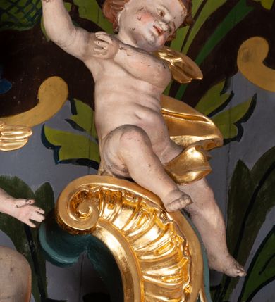 Zdjęcie nr 9: Ołtarz przyścienny, architektoniczny, jednoosiowy, jednokondygnacyjny ze zwieńczeniem. Mensa prostopadłościenna na niskim cokole. Nastawa ołtarzowa ustawiona na wysokim dwustrefowym cokole. Retabulum ujęte parą kolumn o stylizowanych, jońskich głowicach. Podpory wspierają belkowanie o wklęsłym wykroju, przerwane w części środkowej. Na gzymsie odcinki przyczółka o wolutowo skręconych końcach, skierowanych do wewnątrz. Zwieńczenie o wklęsłych bokach, zamknięte, dwoma stykającymi się wolutami z glorią promienistą. Pośrodku glorii symbol Opatrzności Bożej z IHS. Pole środkowe w formie prostokątnej wnęki ujętej ornamentem rocaille’owym. We wnęce rzeźbiony krucyfiks, zawieszony na tle malowanego pejzażu. Po bokach ołtarza, na osobnych konsolach ustawione figury Matki Boskiej po lewej oraz św. Jana Ewangelisty po prawej stronie. Po bokach zwieńczenia, na belkowaniu dwie pary rzeźbionych, uskrzydlonych aniołków. Boki wnęki środkowej dekorowane ornamentem rocaille’owym. Fontowe ścianki cokołów zdobione ażurowymi, wolutowo zwiniętymi liśćmi akantu. W zwieńczeniu obraz z przedstawieniem św. Michała Archanioła ujęty ramą formowaną z motywów „C” kształtnych. Struktura ołtarza malowana w kolorze niebieskim, boki mensy z prostokątnymi jasnobrązowymi płycinami, detal architektoniczny i profilowania złocone.

Figury uskrzydlonych aniołów pełnoplastyczne, ścięte z tyłu, siedzące na obłokach powyżej belkowania retabulum. Anioł po prawej stronie o szeroko rozłożonych rękach, głowie przechylonej w prawą stronę (h.). Anioł po lewej z rękoma uniesionymi, skierowanymi w prawo, głowa lekko pochylona, zwrócona w lewo. Figury niemal nagie, ze złotą przepaską wokół bioder. Twarze owalne o wydatnym czole okolone jasnobrązowymi włosami. Karnacja ciała w jasnokremowym odcieniu.