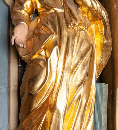 Zdjęcie nr 16: Ołtarz przyścienny, architektoniczny, jednoosiowy, jednokondygnacyjny ze zwieńczeniem. Mensa prostopadłościenna na niskim cokole. Nastawa ołtarzowa ustawiona na wysokim dwustrefowym cokole. Retabulum ujęte parą kolumn o stylizowanych, jońskich głowicach. Podpory wspierają belkowanie o wklęsłym wykroju, przerwane w części środkowej. Na gzymsie odcinki przyczółka o wolutowo skręconych końcach, skierowanych do wewnątrz. Zwieńczenie o wklęsłych bokach, zamknięte, dwoma stykającymi się wolutami z glorią promienistą. Pośrodku glorii symbol Opatrzności Bożej z IHS. Pole środkowe w formie prostokątnej wnęki ujętej ornamentem rocaille’owym. We wnęce rzeźbiony krucyfiks, zawieszony na tle malowanego pejzażu. Po bokach ołtarza, na osobnych konsolach ustawione figury Matki Boskiej po lewej oraz św. Jana Ewangelisty po prawej stronie. Po bokach zwieńczenia, na belkowaniu dwie pary rzeźbionych, uskrzydlonych aniołków. Boki wnęki środkowej dekorowane ornamentem rocaille’owym. Fontowe ścianki cokołów zdobione ażurowymi, wolutowo zwiniętymi liśćmi akantu. W zwieńczeniu obraz z przedstawieniem św. Michała Archanioła ujęty ramą formowaną z motywów „C” kształtnych. Struktura ołtarza malowana w kolorze niebieskim, boki mensy z prostokątnymi jasnobrązowymi płycinami, detal architektoniczny i profilowania złocone.

Figury uskrzydlonych aniołów pełnoplastyczne, ścięte z tyłu, siedzące na obłokach powyżej belkowania retabulum. Anioł po prawej stronie o szeroko rozłożonych rękach, głowie przechylonej w prawą stronę (h.). Anioł po lewej z rękoma uniesionymi, skierowanymi w prawo, głowa lekko pochylona, zwrócona w lewo. Figury niemal nagie, ze złotą przepaską wokół bioder. Twarze owalne o wydatnym czole okolone jasnobrązowymi włosami. Karnacja ciała w jasnokremowym odcieniu.