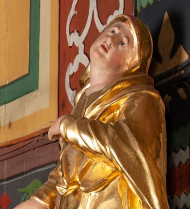 Zdjęcie nr 1: Całopostaciowa, lekko ścięta z tyłu figura Matki Boskiej Bolesnej zwróconej na wprost i stojącej w wydatnym kontrapoście. Sylwetka ciała esowato wygięta, tułów i głowa odchylone do tyłu. Głowa uniesiona, mocno zwrócona w lewą stronę. Owalna twarz o łagodnych rysach, oczy niewielkie, usta rozchylone. Maria ubrana w długą, złoconą suknię oraz złocony płaszcz okrywający głowę, zawinięty wokół lewego ramienia. Prawa ręka lekko uniesiona, lewa podtrzymująca na piersi połę płaszcza. Karnacja ciała w jasnokremowym odcieniu.