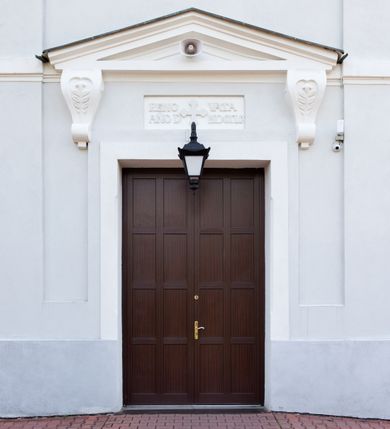 Zdjęcie nr 17: Murowany kościół otrzymał układ jednonawowej świątyni z węższym prezbiterium zwróconym ku północy i wieżą dostawioną do nawy od południa. Prezbiterium jest jednoprzęsłowe zakończone spłaszczoną apsydą. Na jego przedłużeniu usytuowano czworoboczną zakrystię. Prostokątna nawa jest trójprzęsłowa o zaokrąglonych narożnikach. Od frontu wzniesiono czworoboczną wieżę o ściętych narożnikach, flankowaną piętrowymi lokalnościami. Wysunięto ją lekko ku przodowi, gdzie przechodzi wklęsłymi płaszczyznami w boczne części fasady. Jej górne piętro nakryte cebulastym hełmem zostało opięte po bokach wolutami, obok których ustawiono kamienne klasycystyczne wazy. Elewacje zewnętrzne artykułowano podziałami ramowymi, zamykając wysokości ścian gzymsem gurtowy. Na końcu nawy na siodłowym dachu pokrytym blachą umieszczono czworoboczną wieżyczkę na sygnaturkę zwieńczoną cebulastym hełmem z krzyżem. Podobnym dachem nakryto prezbiterium. Wnętrze kościoła zostało rozczłonkowane lizenami z wklęsłymi półlizenami po bokach, ponad którymi rozciągnięto odcinki belkowania. Całość nakryto sklepieniem żaglastym na zdwojonych gurtach. Od południa w nawie urządzono chór muzyczny wsparty na dwóch kolumnach z parapetem wklęsłowypukłym. W prezbiterium usytuowano ołtarz główny, a w nawie dwa ołtarze boczne. Tu także na ścianie zachodniej zawieszono ambonę.  