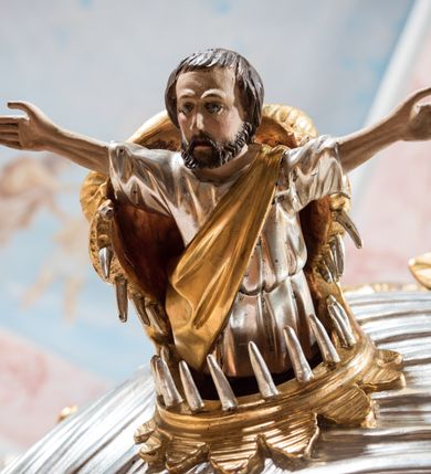 Zdjęcie nr 9: Rokokowa ambona przyścienna uzyskała kształt ożaglowanego okrętu. Składa się z kosza w formie beczkowej łodzi oraz zaplecka w kształcie żagla przechodzącego w baldachim. Kosz został podzielony na dwie strefy. W dolnej przedstawiono stylizowane, srebrzone fale morskie z igrającymi w nich morskimi, złoconymi stworami. Jeden z nich połyka postać Jonasza. Natomiast górną strefę udekorowano złoconymi, rokokowymi kartuszami, skrzyżowanymi dwoma wiosłami okrytymi fragmentem sieci rybackiej na brązowym tle. Z prawej strony do kosza przymocowano złoconą wolutę zdobioną motywem rocalliowym przechodzącym w srebrzony sztandar przymocowany do złotej laski krzyżowej. W zaplecek ambony w kształcie srebrzonego, rozpostartego żagla wstawiono nowy obraz w kształcie stojącego prostokąta, ukazujący błogosławiącego Chrystusa. Zbawiciel został przedstawiony frontalnie w dwóch trzecich postaci z głową i spojrzeniem skierowanym w górę. Prawą ręką błogosławi, lewą zaś przyciska do piersi. Jezus ma pociągłą twarz o wydatnym nosie i ustach, otoczoną brodą i długimi włosami spływającymi na ramiona. Ubrany jest w białą tunikę oraz w przerzucony przez ramię czerwony płaszcz. Jego głowę okala świetlisty nimb na ciemnym tle. Powyżej rozpięty jest baldachim utworzony z masztu podtrzymywanego przez liny i zwisających żagli zakończonych motywem lambrekinowym. Na baldachimie stoi postać uskrzydlonego anioła w luźnej, niebieskiej tunice. Ponad nim na złoconym maszcie umieszczone dwie korony, jedna nad drugą. Na jego szczycie znajduje się gloria z Duchem Świętym w postaci gołębicy na tle srebrzystych obłoków i złotych promieni. Od wschodu do ambony przylegają schody z pełną balustradą artykułowaną romboidalnym płycinami o złoconych krawędziach z polem wypełnionym złoconym motywem rocalliowym. 