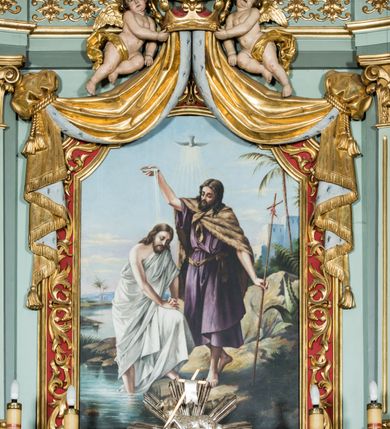 Zdjęcie nr 6: Ołtarz główny uzyskał formę przyściennej, dwukondygnacyjnej, neoklasycystycznej nastawy wzniesionej na rzucie elipsy z bocznymi bramkami. Stipes ołtarzowy uzyskał kształt leżącego prostopadłościanu podtrzymującego drewnianą mensę z portatylem. Jego lico dekorowane jest trzema równoległymi płycinami utworzonymi ze złoconych, profilowanych listew. Na mensie ustawiono prostopadłościenne tabernakulum w formie skrzynki flankowane parą pilastrów podtrzymujących nastawę tronu eucharystycznego. Ujmują go po bokach pary złoconych kolumn z korynckimi kapitelami podtrzymujące belkowanie wygięte na osi półkoliście. Na zwieńczeniu tabernakulum ustawiono leżącego na zamkniętej księdze z siedmioma pieczęciami srebrnego baranka apokaliptycznego na tle srebrzonych promieni. Pomiędzy kolumnami w polu zainstalowano obrotowy bęben z dwiema półkolistymi niszami. Retabulum zostało wsparte na wysokim cokole. Dolną kondygnację artykułują zwielokrotnione pilastry o kanelowanych trzonach i złoconych, kompozytowych głowicach oraz dwie wysunięte do przodu kanelowane kolumny o kapitelach kompozytowych. Podpory podtrzymują szeroki architraw wklęsło-wypukły dekorowany motywami roślinnymi oraz perełkami i ząbkami, wyłamany na przedłużeniu kolumn. W miejscu wyłamań usytuowano siedzących dwóch uskrzydlonych aniołów. Po bokach kolumn na konsolach ustawiono figury św. Piotra i św. Pawła. Boki ołtarza zamykają ażurowe wici roślinne pełniące rolę zredukowanych uszaków. W polu środkowym retabulum umieszczono prostokątne obramienie utworzone z dekoracyjnej ramy zdobionej wicią roślinną oraz podwieszonego u jej góry paludamentum z koroną podtrzymywaną przez dwa aniołki. W środku zainstalowano obraz Matki Boskiej Śnieżnej, a na zasuwie przedstawienie Chrztu Chrystusa w Jordanie. Zwieńczenie nastawy uzyskało kształt leżącego prostokąta flankowanego po bokach parą kanelowanych pilastrów o korynckich głowicach, na tle których ustawiono dwie kolumny podtrzymujących przerwane belkowanie z przerwanym przyczółkiem. Na osi zwieńczenia na postumencie ustawiono rzeźbę św. Michała Archanioła, a na przyczółkach rzeźby dwóch siedzących aniołów. W polu między pilastrami i kolumnami znalazło się płaskorzeźbione przedstawienie Trójcy Przenajświętszej. Dwie flankujące retabulum bramki ozdobiono dwoma aniołkami siedzącymi na ich zwieńczeniu na postumencie. Struktura całości pomalowane jest na zielono, ornamenty i profile wyzłocono, a rzeźby otrzymały naturalistyczną polichromię.