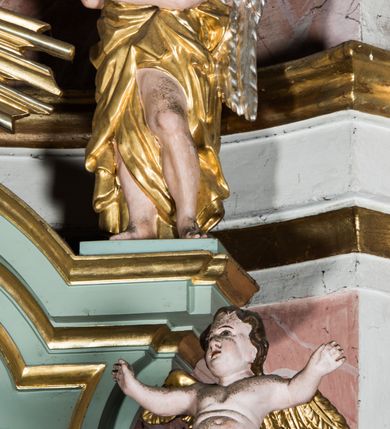 Zdjęcie nr 4: Wczesnoklasycystyczny, przyścienny ołtarz boczny, uzyskał kształt płaskiej nastawy jednokondygnacyjnej ze zwieńczeniem. Sarkofagowy stipes podtrzymuj drewnianą mensę przylegającą do wysokiego cokołu, na którym wzniesiono retabulum ujęte w boczne kanelowane pilastry o kompozytowych głowicach, podtrzymujących wyłamane po zewnętrznych belkowanie, dodatkowo wsparte w narożach na dwóch wolutowych konsolach dekorowanych motywem stylizowanej muszli. Na belkowaniu widoczny jest przerwany przyczółek, na którym usytuowano dwa siedzące, uskrzydlone aniołki. W polu między pilastrami usytuowano ornamentalną, czworoboczną ramę stanowiącą obramienie dla obrazu Matki Boskiej Różańcowej oraz umieszczonego na zasuwie obrazu Świętej Rodziny. Poniżej ramy zamontowano obraz Matki Boskiej Nieustającej Pomocy ujęty dwiema gablotami z wotami. Na tle pilastrów ustawiono dwie rzeźby niezidentyfikowanych świętych niewiast. Całoś dolnej kondygnacji flankują girlandy roślinno-kwiatowe pełniące rolę zredukowanych uszaków. Zwieńczenie nastawy uzyskało kształt leżącego prostokąta o wklęsłych bokach, zwieńczonego profilowanym gzymsem ujętym w nadwieszony łuk odcinkowy. Powyżej w promienistej glorii na tle obłoków wyobrażono trójkąt Bożej Opatrzności flankowany dwoma stojącymi aniołami. W polu zwieńczenia znalazła się prostokątna, płaskorzeźbiona płycina z monogramem maryjnym na tle słońca. Ponad nią widoczna jest para płaskorzeźbionych, uskrzydlonych główek anielskich. Struktura całości pomalowane jest na zielono, ornamenty i profile wyzłocono, a rzeźby otrzymały naturalistyczną polichromię.