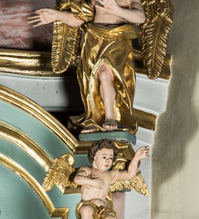 Zdjęcie nr 8: Przyścienny, wczesnoklasycystyczny ołtarz uzyskał formę architektonicznej, jednokondygnacyjnej nastawy ze zwieńczeniem. Sarkofagowy stipes ołtarzowy podtrzymuje drewnianą mensy, na której ustawiono prostopadłościenne tabernakulum w formie skrzynki. Złocone drzwiczki ozdobiono płaskorzeźbionym przedstawieniem kielicha ustawionego na obłokach z hostią otoczoną promieniami. Tabernakulum flankują dwie wypukło wklęsłe płyciny zawierające obraz ze scena pokłonu Trzech Króli oraz Zmartwychwstanie Chrystusa. Powyżej wzniesiono retabulum artykułowane po bokach kanelowanymi pilastrami z kompozytowymi głowicami, podtrzymującymi wyłamane po zewnętrznych belkowanie, dodatkowo wsparte na ustawionych w narożach konsolach. Konsole ozdobiono ornament z motywem  stylizowanej muszli. Na belkowaniu wsparto przerwany przyczółek, na bokach którego siedzą dwa uskrzydlone anioły. Zwieńczenie utworzono z lezącego prostokąta o wklęsłych bokach zwieńczonego profilowanym gzymsem ujętym w nadwieszony łuk odcinkowy. Na jego szczycie po bokach ustawiono dwa stojące uskrzydlone anioły. W polu zwieńczenia znalazł się płaskorzeźbiony chrystogram "IHS" w promienistej glorii. Powyżej umieszczono parę uskrzydlonych główek anielskich. Z kolei w polu kondygnacji między pilastrami usytuowano półokrągłą niszę z figurą Najświętszego Serca Pana Jezusa. Na tle pilastrów dostawione zostały posągi św. Barbary i św. Marii Magdaleny. Struktura została pomalowana w kolorze jasnego seledynu, ornamenty i profile wyzłocono, a rzeźby otrzymały naturalistyczną polichromię.