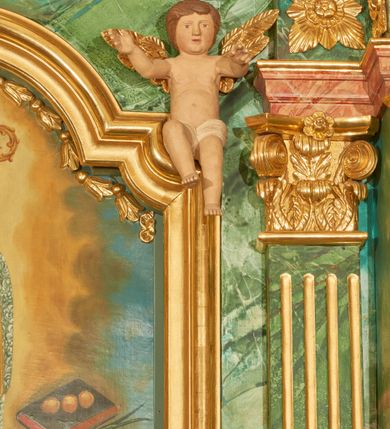 Zdjęcie nr 11: Nastawa ołtarzowa architektoniczna, jednoosiowa, jednokondygnacyjna. Ołtarz prostopadłościenny, drewniany, z drewnianą mensą na niskim cokole, flankowaną po bokach parą kanelowanych pilastrów o kapitelach jońskich. Antependium w formie płyciny marmoryzowanej na kolor różowy w kształcie leżącego prostokąta o owalnych narożach, ujęte w złoconą i wąską ramę. W polu płaskorzeźbione narzędzia Męki Pańskiej (krzyż, włócznia i korona cierniowa). 

Cokół nastawy zryzalitowany, wysoki, zdobiony płycinami z rozetami. Kondygnacja ujęta jest od wewnątrz parą pilastrów o kanelowanych trzonach, a od zewnątrz parą marmoryzowanych na zielono filarów i ustawioną przed nimi parą kolumn o kanelowanych i marmoryzowanych na różowo trzonach. Podpory ustawione są na bazach, mają kompozytowe kapitele i wspierają imposty oraz przerwane nad polem środkowym belkowanie, dekorowane profilowaniem i pasem kostkowania, a także przerwany, wolutowy przyczółek z parą aniołków. Nad środkiem belkowania nad dwóch niewielkich, spiętych spływach wolutowych ustawiona jest niewielkich rozmiarów rzeźbiona grupa przedstawiająca Boga Ojca po prawej i Jezusa Chrystusa po lewej stronie. Nad retabulum, nad wnęką okienną zawieszona jest gołębica Ducha Świętego w dużej promienistej glorii o promieniach, zebranych w wiązki nierównej długości. Retabulum po bokach ujęte jest uszami w formie ażurowej wici z ornamentu rocaille'owego.

W polu środkowym w szerokiej ramie w kształcie stojącego prostokąta, zamkniętego łukiem wklęsło-wypukłym z uskokami umieszczony jest obraz św. Mikołaja oraz św. Barbary na zasuwie. W zwieńczeniu ramy po bokach usadzona jest para aniołków. Poniżej obrazu fantazyjna, architektoniczna oprawa z umieszczonym w polu obrazem św. Teresy z Lisieux. Oprawa w formie niewielkiej, płaskiej aediculi, ustawionej na niskim cokole, flankowanej dwoma pilastrami, zamkniętej łukiem nadwieszonym, na szczycie którego niski cokolik na krucyfiks. Po bokach uszy o fantazyjnym wykroju, z wycięciem w górnej połowie, w dolnej zdobione kratką.

Struktura marmoryzowana jest w odcieniu niebieskim i jasnoróżowym; ornamentyka, profile, ramy i kanelury na pilastrach są złocone.