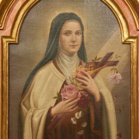 Zdjęcie nr 1: Obraz w kształcie prostokąta stojącego zamkniętego łukiem nadwieszonym z przedstawieniem św. Teresy od Dzieciątka Jezus. Święta ukazana jest w półpostaci, delikatnie zwrócona w swoją lewą stronę, z krucyfiksem oplecionym różowymi, czerwonymi i żółtymi różami w dłoniach. Twarz owalna, usta wąskie, oczy migdałowe, długi nos. Ubrana jest w habit karmelitański z narzuconym na plecy, spiętym pod szyją białym płaszczem. Na krzyż z prawej strony obrazu pada smuga światła. Wokół głowy świętej znajduje się złoty i okrągły nimb. Tło szare. Rama drewniana, profilowana i złocona.
