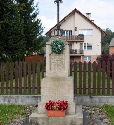 Zdjęcie nr 45: Kościół pomocniczny pw. Wniebowzięcia Najświętszej Marii Panny w Woli Radziszowskiej to niewielkich rozmiarów, orientowana, jednonawowa budowla drewniana, konstrukcji zrębowej, z wieżą w słup. Prezbiterium jest zamknięte wielobocznie, nieco wyższa i szersza nawa ma rzut prostokąta zbliżonego do kwadratu. Do prezbiterium od strony północnej przylega zakrystia, od wschodniej Ogrójec, przy nawie od południa umieszczona została niewielka, prostokątna kruchta. Od zachodu do budowli dostawiona jest czworoboczna wieża o pochyłych ścianach, z podwieszoną izbicą z czworobocznymi występami na przekątnikach; hełm ostrosłupowy z czterema wieżyczkami na występach. W przyziemiu wieży znajduje się kruchta, a dookoła wieży szalowane soboty. Wewnątrz świątyni stropy; w nawie z zaskrzynieniami. Otwór tęczowy ma kształt ostrołuku, belka jest profilowana, na niej umieszczony jest krucyfiks o charakterze późnogotyckim. Chór muzyczny w zachodniej części nawy jest drewniany, wsparty na dwóch kolumnach. Okna nawy i prezbiterium są głównie prostokątne zamknięte półkoliście; z witrażami (z wyjątkiem okna za ołtarzem głównym); ponadto budowlę doświetlają niewielkie okienka prostokątne. Do świątyni prowadzi dwoje drzwi ostrołukowych, trzecie od strony zachodniej przerobiono w 1933 roku. Dachy kościoła są kryte gontem, ponad nawą i kruchtą południową dwuspadowe, nad zakrystią jednospadowy, nad prezbiterium wielopołaciowy. Wieżyczka na sygnaturkę o formach barokowych z glorietą, cebulastym hełmem zwieńczonym kulą oraz krzyżem; kryta blachą. Świątynia usytuowana jest na niewielkiej działce, wydzielonej ogrodzeniem z drewnianych bali, krytym gontem. Bramy wiodące na posesję umieszczono od zachodu oraz w południowo-wschodnim narożniku działki.