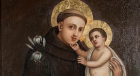 Zdjęcie nr 1: Obraz w kształcie stojącego prostokąta z przedstawieniem św. Antoniego Padewskiego z Dzieciątkiem. Święty został ukazany w ujęciu do kolan, zwrócony w lewo, w stronę Dzieciątka stojącego na blacie przykrytym czerwonym obrusem. Głowa świętego jest delikatnie przechylona w lewo, lewa ręka obejmuje Dzieciątko, prawa opuszczona trzyma kwiat lilii. Święty ma owalną twarz o młodzieńczych rysach, na głowie tonsurę. Jest ubrany w habit franciszkański. Dzieciątko ukazane zostało niemal nagie, z białą chustą okrywającą biodro i przerzuconą przez prawe ramię. Prawą ręką Chrystus dotyka brody świętego, lewą wyciąga w jego stronę. U stóp Dzieciątka leży otwarta księga. Wokół głów postaci złote nimby. Tło kompozycji jednolite, ciemnobrązowe. Na odwrocie napis malowany farbą „Fundator Walenty / Tekiela. / 1840. / 24 lipca”.