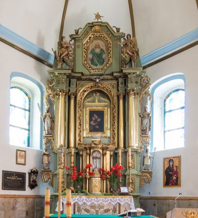 Zdjęcie nr 1: Ołtarz przyścienny, architektoniczny, jednoosiowy, dwukondygnacyjny ze zwieńczeniem. Mensa prostopadłościenna z kamiennym blatem z portatylem, boki mensy z polerowanych płyt kamiennych. Dekoracja antepedium współczesna z aplikowanych metalowych motywów kielicha z hostią i kłosów. Retabulum ujęte parą kolumn korynckich ustawionych na schodkowych cokołach podzielonych gzymsem na dwie strefy. Podpory wspierają belkowanie przerwane w partii architrawu i fryzu nad polem środkowym. Belkowanie zamknięte wydatnym, profilowanym, wyłamanym gzymsem. Powyżej, na osiach zewnętrznych kolumn ustawione odcinki falistego przyczółka o wolutowo skręconych końcach. W polu środkowym wnęka w kształcie stojącego prostokąta zamknięta łukiem półkolistym, na kluczu łuku rzeźba gołębicy Ducha Świętego. Wewnątrz prostokątny otwór na obraz – wymiennie przedstawienie św. Marii Magdaleny pod krzyżem, „Noli me tangere” oraz wizerunek Marki Boskiej Myślenickiej. Zwieńczenie ujęte parą pilastrów, zamknięte trójbocznie z ośmiobocznym polem środkowym. Wnęka pola środkowego retabulum i zwieńczenia ujęta szeroką, ażurową ramą formowaną z wolutowo skręconych liści akantu. W zwieńczeniu obraz przedstawiający Boga Ojca. Ściany cokołów dekorowane płycinami wypełnionymi skręconymi liśćmi akantu. Poniżej gzymsu zamykającego retabulum ażurowy ornament akantowy. U góry boki nastawy ujęte ażurowymi uszakami formowanymi ze skręconych liści akantu, poniżej tworzących parę konsolek. Zwieńczenie ujęte uszakami formowanymi z ornamentu małżowinowo-chrząstowego. Na gzymsie zwieńczenia rzeźbione wazony i czworoliść z monogramem IHS na tle glorii promienistej. Na konsolkach po bokach retabulum ustawione figury św. Wojciecha i świętego z księgą po lewej oraz św. Stanisława i świętego z pastorałem po prawej stronie. Na odcinkach przyczółka figury uskrzydlonych aniołów. Całość struktury retabulum malowana w kolorze jasnozielonym. Detal architektoniczny, profilowania i ornamentyka złocone. 