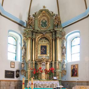 Zdjęcie nr 1: Ołtarz przyścienny, architektoniczny, jednoosiowy, dwukondygnacyjny ze zwieńczeniem. Mensa prostopadłościenna z kamiennym blatem z portatylem, boki mensy z polerowanych płyt kamiennych. Dekoracja antepedium współczesna z aplikowanych metalowych motywów kielicha z hostią i kłosów. Retabulum ujęte parą kolumn korynckich ustawionych na schodkowych cokołach podzielonych gzymsem na dwie strefy. Podpory wspierają belkowanie przerwane w partii architrawu i fryzu nad polem środkowym. Belkowanie zamknięte wydatnym, profilowanym, wyłamanym gzymsem. Powyżej, na osiach zewnętrznych kolumn ustawione odcinki falistego przyczółka o wolutowo skręconych końcach. W polu środkowym wnęka w kształcie stojącego prostokąta zamknięta łukiem półkolistym, na kluczu łuku rzeźba gołębicy Ducha Świętego. Wewnątrz prostokątny otwór na obraz – wymiennie przedstawienie św. Marii Magdaleny pod krzyżem, „Noli me tangere” oraz wizerunek Marki Boskiej Myślenickiej. Zwieńczenie ujęte parą pilastrów, zamknięte trójbocznie z ośmiobocznym polem środkowym. Wnęka pola środkowego retabulum i zwieńczenia ujęta szeroką, ażurową ramą formowaną z wolutowo skręconych liści akantu. W zwieńczeniu obraz przedstawiający Boga Ojca. Ściany cokołów dekorowane płycinami wypełnionymi skręconymi liśćmi akantu. Poniżej gzymsu zamykającego retabulum ażurowy ornament akantowy. U góry boki nastawy ujęte ażurowymi uszakami formowanymi ze skręconych liści akantu, poniżej tworzących parę konsolek. Zwieńczenie ujęte uszakami formowanymi z ornamentu małżowinowo-chrząstowego. Na gzymsie zwieńczenia rzeźbione wazony i czworoliść z monogramem IHS na tle glorii promienistej. Na konsolkach po bokach retabulum ustawione figury św. Wojciecha i świętego z księgą po lewej oraz św. Stanisława i świętego z pastorałem po prawej stronie. Na odcinkach przyczółka figury uskrzydlonych aniołów. Całość struktury retabulum malowana w kolorze jasnozielonym. Detal architektoniczny, profilowania i ornamentyka złocone. 