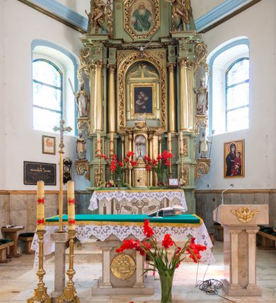 Zdjęcie nr 3: Ołtarz przyścienny, architektoniczny, jednoosiowy, dwukondygnacyjny ze zwieńczeniem. Mensa prostopadłościenna z kamiennym blatem z portatylem, boki mensy z polerowanych płyt kamiennych. Dekoracja antepedium współczesna z aplikowanych metalowych motywów kielicha z hostią i kłosów. Retabulum ujęte parą kolumn korynckich ustawionych na schodkowych cokołach podzielonych gzymsem na dwie strefy. Podpory wspierają belkowanie przerwane w partii architrawu i fryzu nad polem środkowym. Belkowanie zamknięte wydatnym, profilowanym, wyłamanym gzymsem. Powyżej, na osiach zewnętrznych kolumn ustawione odcinki falistego przyczółka o wolutowo skręconych końcach. W polu środkowym wnęka w kształcie stojącego prostokąta zamknięta łukiem półkolistym, na kluczu łuku rzeźba gołębicy Ducha Świętego. Wewnątrz prostokątny otwór na obraz – wymiennie przedstawienie św. Marii Magdaleny pod krzyżem, „Noli me tangere” oraz wizerunek Marki Boskiej Myślenickiej. Zwieńczenie ujęte parą pilastrów, zamknięte trójbocznie z ośmiobocznym polem środkowym. Wnęka pola środkowego retabulum i zwieńczenia ujęta szeroką, ażurową ramą formowaną z wolutowo skręconych liści akantu. W zwieńczeniu obraz przedstawiający Boga Ojca. Ściany cokołów dekorowane płycinami wypełnionymi skręconymi liśćmi akantu. Poniżej gzymsu zamykającego retabulum ażurowy ornament akantowy. U góry boki nastawy ujęte ażurowymi uszakami formowanymi ze skręconych liści akantu, poniżej tworzących parę konsolek. Zwieńczenie ujęte uszakami formowanymi z ornamentu małżowinowo-chrząstowego. Na gzymsie zwieńczenia rzeźbione wazony i czworoliść z monogramem IHS na tle glorii promienistej. Na konsolkach po bokach retabulum ustawione figury św. Wojciecha i świętego z księgą po lewej oraz św. Stanisława i świętego z pastorałem po prawej stronie. Na odcinkach przyczółka figury uskrzydlonych aniołów. Całość struktury retabulum malowana w kolorze jasnozielonym. Detal architektoniczny, profilowania i ornamentyka złocone. 