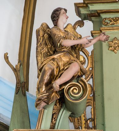 Zdjęcie nr 12: Ołtarz przyścienny, architektoniczny, jednoosiowy, dwukondygnacyjny ze zwieńczeniem. Mensa prostopadłościenna z kamiennym blatem z portatylem, boki mensy z polerowanych płyt kamiennych. Dekoracja antepedium współczesna z aplikowanych metalowych motywów kielicha z hostią i kłosów. Retabulum ujęte parą kolumn korynckich ustawionych na schodkowych cokołach podzielonych gzymsem na dwie strefy. Podpory wspierają belkowanie przerwane w partii architrawu i fryzu nad polem środkowym. Belkowanie zamknięte wydatnym, profilowanym, wyłamanym gzymsem. Powyżej, na osiach zewnętrznych kolumn ustawione odcinki falistego przyczółka o wolutowo skręconych końcach. W polu środkowym wnęka w kształcie stojącego prostokąta zamknięta łukiem półkolistym, na kluczu łuku rzeźba gołębicy Ducha Świętego. Wewnątrz prostokątny otwór na obraz – wymiennie przedstawienie św. Marii Magdaleny pod krzyżem, „Noli me tangere” oraz wizerunek Marki Boskiej Myślenickiej. Zwieńczenie ujęte parą pilastrów, zamknięte trójbocznie z ośmiobocznym polem środkowym. Wnęka pola środkowego retabulum i zwieńczenia ujęta szeroką, ażurową ramą formowaną z wolutowo skręconych liści akantu. W zwieńczeniu obraz przedstawiający Boga Ojca. Ściany cokołów dekorowane płycinami wypełnionymi skręconymi liśćmi akantu. Poniżej gzymsu zamykającego retabulum ażurowy ornament akantowy. U góry boki nastawy ujęte ażurowymi uszakami formowanymi ze skręconych liści akantu, poniżej tworzących parę konsolek. Zwieńczenie ujęte uszakami formowanymi z ornamentu małżowinowo-chrząstowego. Na gzymsie zwieńczenia rzeźbione wazony i czworoliść z monogramem IHS na tle glorii promienistej. Na konsolkach po bokach retabulum ustawione figury św. Wojciecha i świętego z księgą po lewej oraz św. Stanisława i świętego z pastorałem po prawej stronie. Na odcinkach przyczółka figury uskrzydlonych aniołów. Całość struktury retabulum malowana w kolorze jasnozielonym. Detal architektoniczny, profilowania i ornamentyka złocone. 