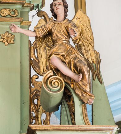 Zdjęcie nr 11: Ołtarz przyścienny, architektoniczny, jednoosiowy, dwukondygnacyjny ze zwieńczeniem. Mensa prostopadłościenna z kamiennym blatem z portatylem, boki mensy z polerowanych płyt kamiennych. Dekoracja antepedium współczesna z aplikowanych metalowych motywów kielicha z hostią i kłosów. Retabulum ujęte parą kolumn korynckich ustawionych na schodkowych cokołach podzielonych gzymsem na dwie strefy. Podpory wspierają belkowanie przerwane w partii architrawu i fryzu nad polem środkowym. Belkowanie zamknięte wydatnym, profilowanym, wyłamanym gzymsem. Powyżej, na osiach zewnętrznych kolumn ustawione odcinki falistego przyczółka o wolutowo skręconych końcach. W polu środkowym wnęka w kształcie stojącego prostokąta zamknięta łukiem półkolistym, na kluczu łuku rzeźba gołębicy Ducha Świętego. Wewnątrz prostokątny otwór na obraz – wymiennie przedstawienie św. Marii Magdaleny pod krzyżem, „Noli me tangere” oraz wizerunek Marki Boskiej Myślenickiej. Zwieńczenie ujęte parą pilastrów, zamknięte trójbocznie z ośmiobocznym polem środkowym. Wnęka pola środkowego retabulum i zwieńczenia ujęta szeroką, ażurową ramą formowaną z wolutowo skręconych liści akantu. W zwieńczeniu obraz przedstawiający Boga Ojca. Ściany cokołów dekorowane płycinami wypełnionymi skręconymi liśćmi akantu. Poniżej gzymsu zamykającego retabulum ażurowy ornament akantowy. U góry boki nastawy ujęte ażurowymi uszakami formowanymi ze skręconych liści akantu, poniżej tworzących parę konsolek. Zwieńczenie ujęte uszakami formowanymi z ornamentu małżowinowo-chrząstowego. Na gzymsie zwieńczenia rzeźbione wazony i czworoliść z monogramem IHS na tle glorii promienistej. Na konsolkach po bokach retabulum ustawione figury św. Wojciecha i świętego z księgą po lewej oraz św. Stanisława i świętego z pastorałem po prawej stronie. Na odcinkach przyczółka figury uskrzydlonych aniołów. Całość struktury retabulum malowana w kolorze jasnozielonym. Detal architektoniczny, profilowania i ornamentyka złocone. 