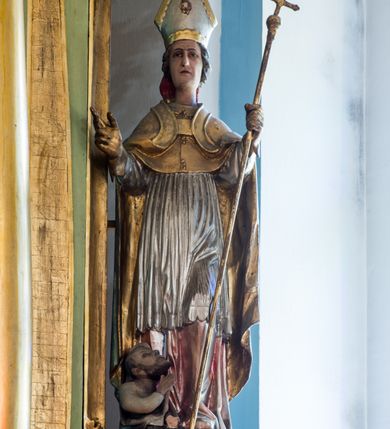 Zdjęcie nr 15: Ołtarz przyścienny, architektoniczny, jednoosiowy, dwukondygnacyjny ze zwieńczeniem. Mensa prostopadłościenna z kamiennym blatem z portatylem, boki mensy z polerowanych płyt kamiennych. Dekoracja antepedium współczesna z aplikowanych metalowych motywów kielicha z hostią i kłosów. Retabulum ujęte parą kolumn korynckich ustawionych na schodkowych cokołach podzielonych gzymsem na dwie strefy. Podpory wspierają belkowanie przerwane w partii architrawu i fryzu nad polem środkowym. Belkowanie zamknięte wydatnym, profilowanym, wyłamanym gzymsem. Powyżej, na osiach zewnętrznych kolumn ustawione odcinki falistego przyczółka o wolutowo skręconych końcach. W polu środkowym wnęka w kształcie stojącego prostokąta zamknięta łukiem półkolistym, na kluczu łuku rzeźba gołębicy Ducha Świętego. Wewnątrz prostokątny otwór na obraz – wymiennie przedstawienie św. Marii Magdaleny pod krzyżem, „Noli me tangere” oraz wizerunek Marki Boskiej Myślenickiej. Zwieńczenie ujęte parą pilastrów, zamknięte trójbocznie z ośmiobocznym polem środkowym. Wnęka pola środkowego retabulum i zwieńczenia ujęta szeroką, ażurową ramą formowaną z wolutowo skręconych liści akantu. W zwieńczeniu obraz przedstawiający Boga Ojca. Ściany cokołów dekorowane płycinami wypełnionymi skręconymi liśćmi akantu. Poniżej gzymsu zamykającego retabulum ażurowy ornament akantowy. U góry boki nastawy ujęte ażurowymi uszakami formowanymi ze skręconych liści akantu, poniżej tworzących parę konsolek. Zwieńczenie ujęte uszakami formowanymi z ornamentu małżowinowo-chrząstowego. Na gzymsie zwieńczenia rzeźbione wazony i czworoliść z monogramem IHS na tle glorii promienistej. Na konsolkach po bokach retabulum ustawione figury św. Wojciecha i świętego z księgą po lewej oraz św. Stanisława i świętego z pastorałem po prawej stronie. Na odcinkach przyczółka figury uskrzydlonych aniołów. Całość struktury retabulum malowana w kolorze jasnozielonym. Detal architektoniczny, profilowania i ornamentyka złocone. 