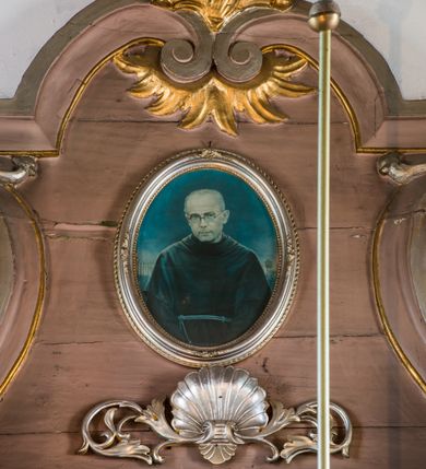 Zdjęcie nr 7: Ołtarz przyścienny, architektoniczny, na cokole. Mensa w typie sarkofagowym; antepedium dekorowane romboidalną plakietą z rozetą na tle liści. Na mensie tabernakulum na rzucie zbliżonym do kwadratu o ściętych przednich narożach, na profilowanej podstawie. Na froncie drzwi w kształcie stojącego prostokąta zamkniętego łukiem półkolistym dekorowane kielichem z hostią; na skośnych ściankach prostokątne płyciny. Zwieńczenie w formie gzymsu. Obok tabernakulum stoją niewielkie, całopostaciowe figurki aniołów – po lewej stronie skłaniającego się w modlitwie, po prawej wyciągającego ręce przed siebie. Nastawa ołtarzowa jednoosiowa, jednokondygnacyjna ze zwieńczeniem. Oś środkowa jest flankowana parą kolumn o kapitelach kompozytowych, ustawionych przed licem ołtarza, na tle zwielokrotnionych pilastrów. Cokoły kolumn dekorowane wieńcami laurowymi. Podpory dźwigają pełne, wyłamane wielokrotnie belkowanie oraz odpowiadające ich ułożeniu cokoły, na których klęczy para modlących się aniołów; na środku, na fryzie belkowania wić roślinna. W polu głównym, we wnęce w kształcie stojącego prostokąta obraz w kształcie takiegoż prostokąta zamkniętego łukiem półkolistym z przedstawieniem św. Józefa z małym Jezusem ujętego ramą z dekoracją w przyłuczach. 
Kondygnację ujmują ażurowe uszaki utworzone z suchej wici akantowej połączonej z rozwiniętymi kwiatkami. Zwieńczenie o kształcie wklęsło-wypukłym, zamknięte od góry łukiem nadwieszonym utworzonym z wolut spiętych płomienistym rocaille’em. Wypełnia je mały owalny obraz z przedstawieniem św. Maksymiliana Kolbe w profilowanej ramie. Spływy zwieńczenia dekorują liście palmowe. 
Struktura polichromowana na kolor jasnobrązowy ze złoconą i srebrzoną ornamentyką oraz detalami architektonicznymi; kolumny białe; tabernakulum białe z różowymi płycinami i złoconymi detalami. 
