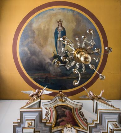 Zdjęcie nr 7: Ołtarz przyścienny, architektoniczny, na cokole. Mensa w typie sarkofagowym; antepedium dekorowane przebitym mieczem gorejącym sercem w wieńcu z róż ujętym kwitnącymi gałązkami. Na mensie tabernakulum na rzucie zbliżonym do prostokąta, na profilowanej podstawie, ujęte spływami wolutowymi. Na licu drzwi w kształcie stojącego prostokąta zamkniętego łukiem półkolistym dekorowane kielichem z hostią, ujęte ustawionymi skośnie pilastrami dźwigającymi pełne belkowanie z wysuniętym gzymsem. Obok tabernakulum stoi figura św. Antoniego Padewskiego. Nastawa jednoosiowa, jednokondygnacyjna ze zwieńczeniem. Oś środkowa flankowana parą kolumn o kapitelach kompozytowych, ustawionych przed licem ołtarza na tle zwielokrotnionych pilastrów. Cokoły kolumn dekorowane płycinami z dekoracją z wici. Podpory dźwigają pełne, wyłamane wielokrotnie belkowanie oraz odpowiadający ich ułożeniu przerwany przyczółek, na którym spoczywa para adorujących aniołów; belkowanie nad częścią środkową ucięte łukowato. W polu środkowym we wnęce w kształcie stojącego prostokąta zamkniętego łukiem nadwieszonym z uskokiem obraz z przedstawieniem Matki Boskiej z Dzieciątkiem w profilowanej ramie z dekoracją płaskorzeźbioną. W ramie ponad obrazem płaskorzeźbiona kompozycja z aniołków trzymających koronę ponad monogramem maryjnym. Powyżej kartusz z napisem „AVE / MARYA”. 
Kondygnację ujmują ażurowe uszaki utworzone z wici roślinnej. Zwieńczenie o kształcie wklęsło-wypukłym, zamknięte od góry łukiem nadwieszonym utworzonym z wolut spiętych muszlą palmetową. Wypełnia je obraz w ramie powtarzającej jego kształt z wizerunkiem św. Cecylii grającej na instrumencie. Zwieńczenie ujmują podobne, ażurowe uszaki. 
Struktura polichromowana na biało ze złoconą ornamentyką oraz detalami architektonicznymi.
