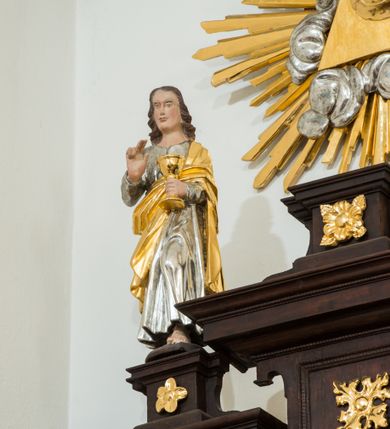 Zdjęcie nr 6: Ołtarz architektoniczny, przyścienny, jednoosiowy, dwukondygnacyjny ze zwieńczeniem. Nastawa umieszczona jest na skrzyniowej mensie. Jej antepedium dekoruje ciemnoróżowa tkanina zdobiona wzorem zwiniętej wici roślinnej. Cokół jest wypełniony w centrum prostokątną płyciną, a na osiach zewnętrznych plakietami ornamentalnymi utworzonymi z motywów roślinnych z dziecięcymi główkami. Nastawa flankowana ustawionymi na wysuniętych partiach cokołu kolumnami dźwigającymi fragmenty pełnego belkowania, które podtrzymują partie urwanego przyczółka. W polu centralnym nisza w kształcie stojącego prostokąta z uskokiem, ponad którym gzyms i łuk półokrągły. W niszy umieszczono ujęty złoconą, ażurową ramą obraz z wizerunkiem św. Andrzeja z 1684 roku (przemalowany) wymiennie z obrazem Najświętszego Serca Jezusa. Powyżej obrazu, w łuku, plakieta dekoracyjna; na kluczu łuku owalne pole ujęte liśćmi. Druga kondygnacja w kształcie leżącego prostokąta z uszakami jest zwieńczona trzema postumentami, z których każdy dźwiga fragment gzymsu podtrzymującego cokół. Na zewnętrznych ustawiono postacie św. Jana Ewangelisty z lewej strony i być może św. Dominika z prawej. Kondygnację ujmują uszaki utworzone z suchej wici akantowej, pole wypełnia owalny obraz z popiersiem Matki Boskiej Niepokalanej. Nastawę wieńczy umieszczone na ścianie oko Opatrzności pośród chmur i w glorii promienistej. 