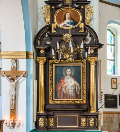 Zdjęcie nr 1: Ołtarz architektoniczny, przyścienny, jednoosiowy, dwukondygnacyjny ze zwieńczeniem. Nastawa umieszczona jest na skrzyniowej mensie. Jej antepedium dekoruje ciemnoróżowa tkanina zdobiona wzorem zwiniętej wici roślinnej. Cokół jest wypełniony w centrum prostokątną płyciną, a na osiach zewnętrznych plakietami ornamentalnymi utworzonymi z motywów roślinnych z dziecięcymi główkami. Nastawa flankowana ustawionymi na wysuniętych partiach cokołu kolumnami dźwigającymi fragmenty pełnego belkowania, które podtrzymują partie urwanego przyczółka. W polu centralnym nisza w kształcie stojącego prostokąta z uskokiem, ponad którym gzyms i łuk półokrągły. W niszy umieszczono ujęty złoconą, ażurową ramą obraz z wizerunkiem św. Andrzeja z 1684 roku (przemalowany) wymiennie z obrazem Najświętszego Serca Jezusa. Powyżej obrazu, w łuku, plakieta dekoracyjna; na kluczu łuku owalne pole ujęte liśćmi. Druga kondygnacja w kształcie leżącego prostokąta z uszakami jest zwieńczona trzema postumentami, z których każdy dźwiga fragment gzymsu podtrzymującego cokół. Na zewnętrznych ustawiono postacie św. Jana Ewangelisty z lewej strony i być może św. Dominika z prawej. Kondygnację ujmują uszaki utworzone z suchej wici akantowej, pole wypełnia owalny obraz z popiersiem Matki Boskiej Niepokalanej. Nastawę wieńczy umieszczone na ścianie oko Opatrzności pośród chmur i w glorii promienistej. 