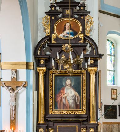 Zdjęcie nr 3: Figura pełna na cokole. Święty Jan ukazany w całej postaci, stojący frontalnie, w kontrapoście, z lewą nogą wysuniętą do przodu. W lewej ręce trzyma kielich, a prawą czyni nad nim gest błogosławieństwa; patrzy przed siebie. Święty ma młodzieńczą, podłużną twarz z asymetrycznie ustawionymi oczami, prostym nosem i wąskimi, silnie zarysowanymi ustami. Długie, ciemnobrązowe włosy zwinięte w pukle opadają mu na plecy. Ubrany jest w srebrną suknię, która fałduje się nad zgiętym kolanem. Na plecy i lewe ramię ma zarzucony złoty płaszcz. Polichromia w odsłoniętych partiach ciała traktowana naturalistycznie.