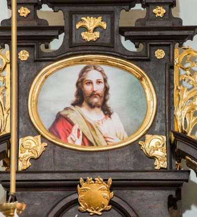 Zdjęcie nr 4: Ołtarz architektoniczny, przyścienny, jednoosiowy, dwukondygnacyjny ze zwieńczeniem. Nastawa umieszczona jest na skrzyniowej mensie, której antepedium dekoruje ciemnoróżowa tkanina zdobiona wzorem zwiniętej wici roślinnej. Cokół jest wypełniony w centrum prostokątną płyciną, a na osiach zewnętrznych plakietami ornamentalnymi utworzonymi z motywów roślinnych z dziecięcymi główkami. Nastawa flankowana ustawionymi na wysuniętych partiach cokołu kolumnami dźwigającymi fragmenty pełnego belkowania, które podtrzymują partie urwanego przyczółka. W polu centralnym nisza w kształcie stojącego prostokąta z uskokiem, ponad którym gzyms i łuk półokrągły. W niszy umieszczono ujęty złoconą, ażurową ramą obraz z wizerunkiem Matki Boskiej Częstochowskiej. Powyżej obrazu, w łuku, plakieta dekoracyjna. Druga kondygnacja w kształcie leżącego prostokąta z uszakami jest zwieńczona trzema postumentami, z których wszystkie dźwigają fragmenty gzymsu podtrzymującego cokoły. Na zewnętrznych ustawiono postacie niezidentyfikowanych świętych. Kondygnację ujmują uszaki utworzone z suchej wici akantowej, pole wypełnia owalny obraz z popiersiem błogosławiącego Jezusa. Nastawę wieńczy umieszczony na ścianie monogram maryjny ujęty w kształt kropi i umieszczony na tle glorii promienistej. 
Struktura polichromowana na kolor ciemnobrązowy ze złoconymi kolumnami oraz złoconą i srebrzoną ornamentyką oraz detalami architektonicznymi.
