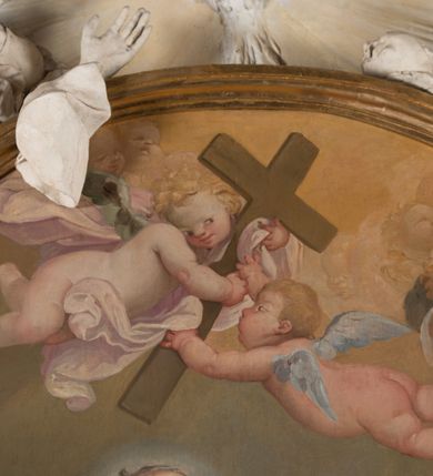 Zdjęcie nr 4: Na niskim postumencie o krawędzi przedniej zarysowanej linią falistą osadzony ołtarz w kształcie tumby, wybrzuszonej w górnej partii. Jego antepedium wypełnione marmoryzacją z owalnym, pustym polem i pękami różnokolorowych kwiatów. Po bokach ołtarza dwa ukośnie dostawione kamienne postumenty, na których dwie figury aniołów flankujących owalny obraz w złoconej ramie z przedstawieniem św. Józefa z Jezusem i grającym na kontrabasie aniołem. Malowidło obwiedzione dekoracją sztukatorską w formie obłoków z główkami lub postaciami aniołów i zwieńczone glorią promienistą z gołębicą Ducha Świętego. Anioły klęczące na postumentach ukazane są w poruszonych pozach, w obficie drapowanych szatach, tworzących grube, mięsiste poły, ze skrzydłami o gęstych piórach. Anioł po lewej stronie jest ukazany frontalnie, klęcząc na chmurze na prawym kolanie, z lewą noga wyprostowaną, z głową w trzech czwartych, zwróconą w swoją prawą stronę. Lewą ręką przytrzymuje ramę obrazu, prawą unosi w geście błogosławieństwa. Anioł po prawej stronie głowę kieruje ku obrazowi, jego ręce są uniesione na wysokości klatki piersiowej, dłoń lewą opuszcza, a prawą unosi. Nad górną częścią obrazu został ukazany anioł w pozycji niemalże leżącej, z rozłożonymi rękami, odziany w bogato drapowane szaty odsłaniające dolną część nogi. Duże skrzydła o gęstych piórach rozłożone są niesymetrycznie. Po przeciwnej stronie leży na chmurach nagie putto wśród modelowanych sumarycznie główek anielskich. Dolne partie wykonane z kamienia inkrustowanego czarnym marmurem i marmoryzacją z różnokolorowymi pękami kwiatów, w jasnych kolorach z czarnym polem antepedium z różnobarwnymi kwiatami, partie rzeźbiarskie białe, rama obrazu złocona, gloria bladoniebieska. 