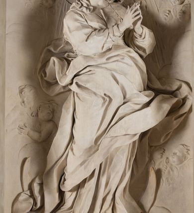 Zdjęcie nr 5: Na niewysokim stopniu prostopadłościenny ołtarz z antepedium, którego dekoracja wykonana w technice marmoryzacji (skaliola) w postaci owalnego pola z wyobrażeniem źródła życia wiecznego (dwa ptaki pijące wodę z fontanny) oraz pęków kwiatów. Nad ołtarzem nastawa z niemal pełnoplastyczną figurą Matki Boskiej Niepokalanej ujęta pilastrami i stojącymi przed nimi marmoryzowanymi kolumnami z kapitelami jońskimi podtrzymującymi szerokie belkowanie zwieńczone naczółkami. W środkowej części belkowania grupa rzeźbiarska z figurą Boga Ojca spoczywającego na obłokach trzymanych przez putta i anioły. Stojąca na obłokach i księżycu Matka Boska ukazana frontalnie, w kontrapoście, z rękami złożonymi do modlitwy. Jej twarz jest modelowana łagodnie, owalna, z długim nosem, otwartymi oczami. Nad głową wieniec z gwiazd. Ubrana jest w długą suknię i rozłożysty płaszcz o skłębionych połach, drapowanych plastycznie. Z tła wyłaniają się putta i uskrzydlone główki aniołów oraz promienie słońca. Postać Boga Ojca siedzącego na chmurach z rozwianymi szatami ukazana frontalnie. Prawą rękę wysuwa do przodu, w lewej trzyma berło. Ołtarz utrzymany w jasnej tonacji kolorystycznej, z elementami z czarnego marmuru i wielobarwnym antepedium w technice marmoryzacji. 