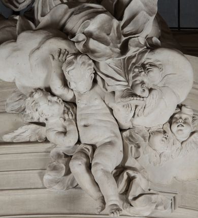 Zdjęcie nr 13: Na niewysokim stopniu prostopadłościenny ołtarz z antepedium, którego dekoracja wykonana w technice marmoryzacji (skaliola) w postaci owalnego pola z wyobrażeniem źródła życia wiecznego (dwa ptaki pijące wodę z fontanny) oraz pęków kwiatów. Nad ołtarzem nastawa z niemal pełnoplastyczną figurą Matki Boskiej Niepokalanej ujęta pilastrami i stojącymi przed nimi marmoryzowanymi kolumnami z kapitelami jońskimi podtrzymującymi szerokie belkowanie zwieńczone naczółkami. W środkowej części belkowania grupa rzeźbiarska z figurą Boga Ojca spoczywającego na obłokach trzymanych przez putta i anioły. Stojąca na obłokach i księżycu Matka Boska ukazana frontalnie, w kontrapoście, z rękami złożonymi do modlitwy. Jej twarz jest modelowana łagodnie, owalna, z długim nosem, otwartymi oczami. Nad głową wieniec z gwiazd. Ubrana jest w długą suknię i rozłożysty płaszcz o skłębionych połach, drapowanych plastycznie. Z tła wyłaniają się putta i uskrzydlone główki aniołów oraz promienie słońca. Postać Boga Ojca siedzącego na chmurach z rozwianymi szatami ukazana frontalnie. Prawą rękę wysuwa do przodu, w lewej trzyma berło. Ołtarz utrzymany w jasnej tonacji kolorystycznej, z elementami z czarnego marmuru i wielobarwnym antepedium w technice marmoryzacji. 