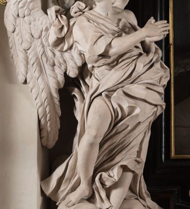 Zdjęcie nr 35: Na niskim postumencie, na rzucie prostokąta z łukiem nadwieszonym od przodu, prostopadłościenny ołtarz z antepedium ujętym szerokimi lizenami z romboidalnymi polami wypełnionymi drobnymi kwiatami, z owalnym polem pośrodku z podłużnymi palmami męczeństwa i bukietami kwiatów wokół. Nad ołtarzem nastawa z obrazem w kształcie stojącego prostokąta z przedstawieniem św. Piotra uwalnianego przez anioła z okowów. Ołtarz jest ujęty ukośnie dostawionymi postumentami z figurami dwóch aniołów flankujących obraz. Anioły ukazane w poruszonych pozach. Lewy stoi w silnym kontrapoście, z prawą nogą opartą na chmurze, z ciałem skierowanym ku środkowi osi ołtarza, z głową odwróconą w kierunku przeciwnym i wysuniętymi przed siebie rękami złożonymi do modlitwy. Jego twarz jest modelowana łagodnie, nos ma długi, usta rozwarte, a włosy skręcone, krótkie. Ubrany w obficie drapowany płaszcz, którego poły układają się w miękkie fałdy, dołem przechodzące między łydkami. Skrzydła ma rozłożyste, modelowane niesymetrycznie, gęsto upierzone. Drugi anioł klęczy na lewej nodze, wspartej na chmurze, zwrócony jest w kierunku obrazu, z prawą ręką przed sobą, a lewą odrzuconą do tyłu. Twarz ma pociągłą, nos wydatny, włosy krótkie, skręcone. Ubrany w długą suknię, drapowaną obficie, odsłaniającą lewe przedramię. Skrzydła rozłożyste, gęsto upierzone. Górna część ramy obrazu z ukośnie wyłamanym gzymsem z podwieszonymi pod nim impostami, podtrzymywanymi przez wyłaniające się z chmur anioły. Gzyms nad obrazem wyłamuje się półkoliście, na nim pośrodku leży anioł trzymający w lewej ręce banderolę ze złoconymi literami nietworzącymi logicznej całości, a prawą ręką wskazujący w kierunku wnętrza kaplicy. U jego boku skłębione chmury z trzema uskrzydlonymi główkami aniołków. Nad bocznymi partiami gzymsu siedzą uskrzydlone, nagie, pulchne aniołki, jeden z rękami złożonymi w geście modlitwy, drugi z rękami uniesionymi i rozłożonymi. Marmoryzacja utrzymana w kolorach brązów, rama i zwieńczenie czarne, dekoracja rzeźbiarska biała. 