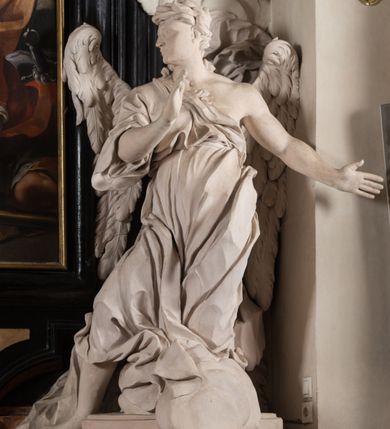 Zdjęcie nr 22: Na niskim postumencie, na rzucie prostokąta z łukiem nadwieszonym od przodu, prostopadłościenny ołtarz z antepedium ujętym szerokimi lizenami z romboidalnymi polami wypełnionymi drobnymi kwiatami, z owalnym polem pośrodku z podłużnymi palmami męczeństwa i bukietami kwiatów wokół. Nad ołtarzem nastawa z obrazem w kształcie stojącego prostokąta z przedstawieniem św. Piotra uwalnianego przez anioła z okowów. Ołtarz jest ujęty ukośnie dostawionymi postumentami z figurami dwóch aniołów flankujących obraz. Anioły ukazane w poruszonych pozach. Lewy stoi w silnym kontrapoście, z prawą nogą opartą na chmurze, z ciałem skierowanym ku środkowi osi ołtarza, z głową odwróconą w kierunku przeciwnym i wysuniętymi przed siebie rękami złożonymi do modlitwy. Jego twarz jest modelowana łagodnie, nos ma długi, usta rozwarte, a włosy skręcone, krótkie. Ubrany w obficie drapowany płaszcz, którego poły układają się w miękkie fałdy, dołem przechodzące między łydkami. Skrzydła ma rozłożyste, modelowane niesymetrycznie, gęsto upierzone. Drugi anioł klęczy na lewej nodze, wspartej na chmurze, zwrócony jest w kierunku obrazu, z prawą ręką przed sobą, a lewą odrzuconą do tyłu. Twarz ma pociągłą, nos wydatny, włosy krótkie, skręcone. Ubrany w długą suknię, drapowaną obficie, odsłaniającą lewe przedramię. Skrzydła rozłożyste, gęsto upierzone. Górna część ramy obrazu z ukośnie wyłamanym gzymsem z podwieszonymi pod nim impostami, podtrzymywanymi przez wyłaniające się z chmur anioły. Gzyms nad obrazem wyłamuje się półkoliście, na nim pośrodku leży anioł trzymający w lewej ręce banderolę ze złoconymi literami nietworzącymi logicznej całości, a prawą ręką wskazujący w kierunku wnętrza kaplicy. U jego boku skłębione chmury z trzema uskrzydlonymi główkami aniołków. Nad bocznymi partiami gzymsu siedzą uskrzydlone, nagie, pulchne aniołki, jeden z rękami złożonymi w geście modlitwy, drugi z rękami uniesionymi i rozłożonymi. Marmoryzacja utrzymana w kolorach brązów, rama i zwieńczenie czarne, dekoracja rzeźbiarska biała. 