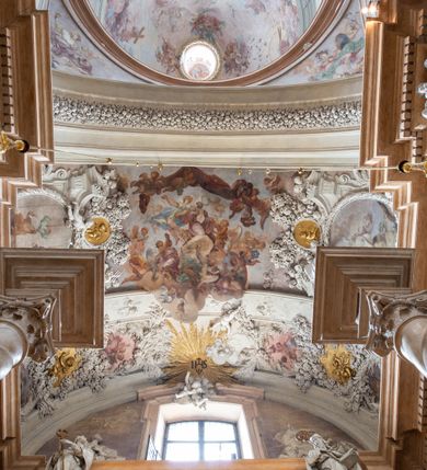 Zdjęcie nr 30: Kościół jest murowany z cegły, z użyciem ciosu kamiennego w partii cokołu i jako okładziny, tynkowany, z kryptami odpowiadającymi rzutowi. Założony jest na rzucie krzyża łacińskiego, z czteroprzęsłową nawą ujętą kaplicami, trójprzęsłowym prezbiterium zamknięty prosto, półtoraprzęsłowymi ramionami nawy poprzecznej, wysuniętymi poza korpus, zamknięte prosto i z kopułą na skrzyżowaniu naw. Przęsło fasady jest ujęte dwiema lokalnościami i dwiema wysuniętymi poza obręb korpusu wieżami z okrągłymi klatkami schodowymi z drewnianymi kręconymi schodami prowadzącymi do pomieszczeń nad lokalnościami. Do prezbiterium przylegają od południowego wschodu zakrystia, od północnego zachodu skarbiec, z składzikami na piętrze. 
Nawa jest artykułowa za pomocą pilastrów kompozytowych, zdwojonych w prezbiterium, transepcie i nawie głównej, zwielokrotniony w krzyżu kościoła, dźwigających wydatne belkowanie. Ściany kaplic są artykułowane za pomocą płytkich, opilastrowanych arkad; mury tarczowe kaplic wydzielone za pomocą gzymsu przełamującego się w narożnikach. Nawa i prezbiterium są sklepione kolebkami na gurtach z lunetami, transept sklepieniem kolebkowym na gurtach, kaplice pseudokopułami na pendentywach (w kaplicy Matki Boskiej i św. Katarzyny kopuły na rzucie elipsy z latarniami), zakrystia i skarbiec sklepieniem krzyżowo-kolebkowo, a przedsionki – nieckowym z lustrem. Okna nawy głównej i prezbiterium w profilowanych obramieniach, prostokątne, zamknięte łukiem segmentowym, okna kaplic są półkoliste. Bęben kopuły rozczłonkowany parami pilastrów kompozytowych, a między nimi rozlokowane naprzemian półkoliście zamknięte nisze i prostokątne okna. Do kościoła prowadzą drzwi wejściowe i para drzwi bocznych, z prezbiterium drzwi wejściowe do skarbca i zakrystii, z zakrystii na dziedziniec przy kościele. 
Fasada poprzedzona schodami, dwukondygnacyjna, dwuwieżowa, w dolnej kondygnacji siedmioosiowa, w górnej trójosiowa z dwiema wyodrębnionymi wieżami. Dolna kondygnacja rozczłonkowana zwojonymi pilastrami i parami kolumn flankujących oś środkową, o kapitelach kompozytowych, podtrzymujących wyłamujące się nad nimi belkowanie z wydatnym gzymsem i attyką, ponad belkowaniem w osi środkowej przerwany przyczółek. Górną kondygnację ujmują pary pilastrów ze stojącymi na ich tle wazonami, dźwigające wyłamujące się nad nimi belkowanie, w części środkowej zwieńczone przyczółkiem, w wieżach – miedzianymi hełmami. 
W części środkowej dolnej kondygnacji znajduje się zamknięta półkoliście wnęka z portalem, ujętym ukośnie dostawionymi pilastrami z konsolami podtrzymującymi naczółki i z tablicą z wklęsłymi bokami, zwieńczoną gzymsem w kształcie łuku nadwieszonego; ponad tablicą znajduje się półkoliste okno. Nad drzwiami bocznymi płaskorzeźbione postacie klęczących aniołów i kwadratowe okna, w wieżach wnęki z figurami św. Bernarda (po lewej) i św. Jana Kantego (po prawej). W części środkowej drugiej kondygnacji umieszczone jest prostokątne okno zamknięte łukiem segmentowym i zwieńczone przerwanym przyczółkiem. W polach bocznych nisze z figurami św. Kazimierza (po lewej) i św. Floriana (po prawej). Ściany boczne wzmocnione szkarpami, podzielone lizenami i pilastrami toskańskimi w dolnej kondygnacji prezbiterium oraz południowo wschodniej i północno zachodniej ścianie transeptu. Prezbiterium i ramiona transeptu zamknięte trójkątnymi szczytami z owalnymi oknami. Tambur kopuły rozczłonkowany lizenami, z oknami zamkniętymi łukami segmentowymi, w profilowanych obramieniach; ośmiopolową kopułę krytą blachą wieńczy latarnia opięta półkolumnami, pomiędzy którymi znajdują się wąskie okna zamknięte półkoliście. Nawę, prezbiterium i transept nakrywa dach siodłowy, nad pozostałymi pomieszczeniami dachy siodłowe, z wyjątkiem środkowych kaplic, w których kopułki wtopione zostały w dach i zwieńczone latarniami.  
