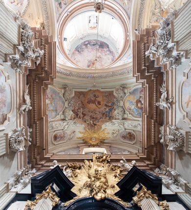 Zdjęcie nr 39: Kościół jest murowany z cegły, z użyciem ciosu kamiennego w partii cokołu i jako okładziny, tynkowany, z kryptami odpowiadającymi rzutowi. Założony jest na rzucie krzyża łacińskiego, z czteroprzęsłową nawą ujętą kaplicami, trójprzęsłowym prezbiterium zamknięty prosto, półtoraprzęsłowymi ramionami nawy poprzecznej, wysuniętymi poza korpus, zamknięte prosto i z kopułą na skrzyżowaniu naw. Przęsło fasady jest ujęte dwiema lokalnościami i dwiema wysuniętymi poza obręb korpusu wieżami z okrągłymi klatkami schodowymi z drewnianymi kręconymi schodami prowadzącymi do pomieszczeń nad lokalnościami. Do prezbiterium przylegają od południowego wschodu zakrystia, od północnego zachodu skarbiec, z składzikami na piętrze. 
Nawa jest artykułowa za pomocą pilastrów kompozytowych, zdwojonych w prezbiterium, transepcie i nawie głównej, zwielokrotniony w krzyżu kościoła, dźwigających wydatne belkowanie. Ściany kaplic są artykułowane za pomocą płytkich, opilastrowanych arkad; mury tarczowe kaplic wydzielone za pomocą gzymsu przełamującego się w narożnikach. Nawa i prezbiterium są sklepione kolebkami na gurtach z lunetami, transept sklepieniem kolebkowym na gurtach, kaplice pseudokopułami na pendentywach (w kaplicy Matki Boskiej i św. Katarzyny kopuły na rzucie elipsy z latarniami), zakrystia i skarbiec sklepieniem krzyżowo-kolebkowo, a przedsionki – nieckowym z lustrem. Okna nawy głównej i prezbiterium w profilowanych obramieniach, prostokątne, zamknięte łukiem segmentowym, okna kaplic są półkoliste. Bęben kopuły rozczłonkowany parami pilastrów kompozytowych, a między nimi rozlokowane naprzemian półkoliście zamknięte nisze i prostokątne okna. Do kościoła prowadzą drzwi wejściowe i para drzwi bocznych, z prezbiterium drzwi wejściowe do skarbca i zakrystii, z zakrystii na dziedziniec przy kościele. 
Fasada poprzedzona schodami, dwukondygnacyjna, dwuwieżowa, w dolnej kondygnacji siedmioosiowa, w górnej trójosiowa z dwiema wyodrębnionymi wieżami. Dolna kondygnacja rozczłonkowana zwojonymi pilastrami i parami kolumn flankujących oś środkową, o kapitelach kompozytowych, podtrzymujących wyłamujące się nad nimi belkowanie z wydatnym gzymsem i attyką, ponad belkowaniem w osi środkowej przerwany przyczółek. Górną kondygnację ujmują pary pilastrów ze stojącymi na ich tle wazonami, dźwigające wyłamujące się nad nimi belkowanie, w części środkowej zwieńczone przyczółkiem, w wieżach – miedzianymi hełmami. 
W części środkowej dolnej kondygnacji znajduje się zamknięta półkoliście wnęka z portalem, ujętym ukośnie dostawionymi pilastrami z konsolami podtrzymującymi naczółki i z tablicą z wklęsłymi bokami, zwieńczoną gzymsem w kształcie łuku nadwieszonego; ponad tablicą znajduje się półkoliste okno. Nad drzwiami bocznymi płaskorzeźbione postacie klęczących aniołów i kwadratowe okna, w wieżach wnęki z figurami św. Bernarda (po lewej) i św. Jana Kantego (po prawej). W części środkowej drugiej kondygnacji umieszczone jest prostokątne okno zamknięte łukiem segmentowym i zwieńczone przerwanym przyczółkiem. W polach bocznych nisze z figurami św. Kazimierza (po lewej) i św. Floriana (po prawej). Ściany boczne wzmocnione szkarpami, podzielone lizenami i pilastrami toskańskimi w dolnej kondygnacji prezbiterium oraz południowo wschodniej i północno zachodniej ścianie transeptu. Prezbiterium i ramiona transeptu zamknięte trójkątnymi szczytami z owalnymi oknami. Tambur kopuły rozczłonkowany lizenami, z oknami zamkniętymi łukami segmentowymi, w profilowanych obramieniach; ośmiopolową kopułę krytą blachą wieńczy latarnia opięta półkolumnami, pomiędzy którymi znajdują się wąskie okna zamknięte półkoliście. Nawę, prezbiterium i transept nakrywa dach siodłowy, nad pozostałymi pomieszczeniami dachy siodłowe, z wyjątkiem środkowych kaplic, w których kopułki wtopione zostały w dach i zwieńczone latarniami.  
