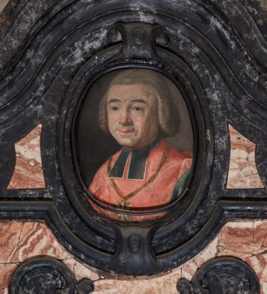 Zdjęcie nr 5: Epitafium w kształcie pionowej płyty, ujętej spływami wolutowymi z kampanulami, z owalnym polem na portret, zwieńczonym profilowanym, falistym gzymsem. U dołu kartusz z herbem własnym (róża przebita strzałą) pod kapeluszem kanonickim, zwieńczony muszlą. Portret ujęty profilowaniem z dwiema zawiniętym na zewnątrz taśmami, przedstawia mężczyznę w popiersiu, w czerwonej pelerynie z zielonymi befkami, z orłem na łańcuchu, z głową ukazaną w trzech czwartych, zwróconą lekko w prawą stronę. Jego twarz jest pełna, o zaczerwienionych policzkach, nos szeroki, oczy otwarte w płytkich oczodołach, spoglądają wprost, usta zamknięte, lekko uśmiechnięte, wyraziście zaznaczone czerwienią. Włosy jasne, zaczesane do tyłu, sięgające szyi, sprawiające wrażenie peruki. Tło nieokreślone, ciemne, w tonacji szarej. Tablica z inskrypcją prostokątna, o zaoblonych, ujętych ceownicami narożach i wyciętych niemal półkoliście krótszych bokach, w niej złocona inskrypcja: "D(EO) O(PTIMO) M(AXIMO) / M. ANTONIUS. ZOŁĘDZIOWSKI / U(TRIUSQUE) J(URIS) S(AGRE) T(HEOLOGIAE) D(OCTOR) P(ROFESSORI) / IN. ACADEMIA. ARCADUM. NORINDUS. CALCEDONIUS. / RECTOR. UNIVERSITATIS. SEPTENNIO. MAGNIFICUS. /  PROCANCELLARUS. / CRACOVIENSIS. CATHEDRALIS. CANONICUS. / APUD. S(UMMI) P(ONTIFICES) MM. / BENEDICTUM. XIV. CLEMENTEM. XIII. / PRO. REFERENDO. III. ALBUM. SANCTORUM. / DIVO. IOANNE. CANTIO. / TRIBUS. LUSTRIS. / FELIX. IN. URBE. POSTULATOR. / PIUS. IUSTUS. LIBERALIS. CARUS. / CUM. VIXISSET. TERRIS. ANNOS. LXXII. / ASTRA. PETIIT. / AE. C. MDCCLXXXIII. IX. KAL(ENDAS) SEPTEMBRIS. / HIC. / RESURRECTIONEM. MORTUORUM. / ET. / VITAM. VENTURI. SECULI. / EXPECTAT. / M(AGNAE) M(AGISTRI) IOSEPHUS. ALOYSIUS. PUTANOWICZ. / PETRUS. IOSEPHUS. RYDULSKI. / SACREA. THEOLOGIE. DOCTORES. / MAESTI. GRATI. EXEQVUTORES. / POSUERE". 