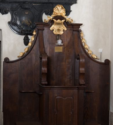 Zdjęcie nr 4: Para konfesjonałów o lekko wybrzuszonym przodzie i wklęsłych bokach, z wysokim zapleckiem ze ściętymi, wklęsłymi bokami, ujętymi spływami wolutowymi. Siedzisko z drzwiczkami ozdobionymi wklęsłą ramą z łukowatymi wcięciami na każdym boku i bokami wyciętymi linią wklęsło-wypukłą, z kratkami. Środkowa część zaplecka zwieńczona profilowanym gzymsem z łukiem nadwieszonymi, w którym znajduje się złocony kartusz ujęty karbowaną taśmą i muszlą palmetową z inskrypcją „KTÓRYCH ODPUŚCICIE / GRZECHY / SĄ IM ODPUSZCZONE / JAN XX. 23”. Nad łukiem muszla palmetowa ujęta wiciami akantu. Wzdłuż spływów wolutowych po bokach złocone kampanule. Do zaplecka, nad siedziskiem zamontowana lampka elektryczna i tabliczka z inskrypcją „W TYM KONFESJONALE SPOWIADAŁ / bł(ogosławiony) Jan Paweł II / ks(iądz) Kardynał Karol Wojtyła / gdy był Pasterzem Kościoła Krakowskiego.”
