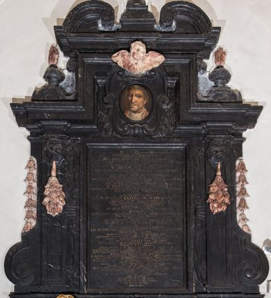 Zdjęcie nr 1: Epitafium w formie stojącego prostokąta wsparte na profilowanym gzymsie z konsolami i podwieszonym pod nim fartuchem z kartuszem z herbem Uniwersytetu Jagiellońskiego, ujęte pilastrami podtrzymującymi przełamujący się w kwadrat gzyms, zwieńczony falistym, przerwanym przyczółkiem z krzyżem pośrodku. Pilastry z kapitelami w formie maszkaronów, trzymających w ustach kiść girland owocowych są ujęte od zewnątrz spływami wolutowymi, od wewnątrz wydłużonymi wolutami. Pośrodku, w górnej wyłamanej części owalny portret zmarłego w kartuszu. Mężczyzna ukazany w popiersiu, z głową w trzech czwartych w prawo, z oczami zwróconymi prosto. Twarz malowana realistycznie, nos szeroki, długi, wargi zaciśnięte, oczy otwarte. Włosy jasne, krótkie, po bokach zaczesane do tyłu; tło nieokreślone, w tonacji brązu. Poniżej inskrypcja: "D(EO) O(PTIMO) M(AXIMO) / LAPIDEM ME QVI TRANSIS VIATOR. / MUTUM NE EXISTIMA / EGO HUIUS QUAM CERNIS FABRICAE LINGVA / AD SCHOLAM REGNI LOQVI DIDICI. / SVB ME IACET. / PER QVEM HAEC MAGNIFICIA STETIT MOLES / M(AGISTER) SEBASTIANUS PISKORSKI / I(URIS) U(TRIUSQUE) D(OCTOR) ET PROFESSOR, CANONICUS CRACOVIENSIS / QVI / UT FORET / SAECULORUM MEMORIA / CUNCTIS AD MENTEM SESE EFFORMAVIT. / AD MAGNORUM PRINCIPUM AULAS MORARI AC AESTIMARI DEBUIT, / CUM MINORIBUS CAPI NON POTERAT / CELSISSIMI &amp; REVERENDISSIMI DOMINI / D(OMINI) STANISLAI IN  SŁUPOW SZEMBEK / ARCHIEPISCOPI GNESNESIS LEGATI NATI REGNI POLONIAE ET M(AGNI) D(UCATVI) L(ITHVANIAE) PRIMATIS / PRINCIPIS, ABBATIS TYNECENSIS / AC / ILLUSTRISSIMI DOMINI / D(OMINI) PRAECLAI CASTELLANI WOYNICENSIS / FRATRUM INTER SE GERMANORUM / NOBILISSIMAM IN PRAETEXTA INDOLEM / DOMESTICUS XII ANNIS PROFESSOR / ERUDITA FOVIT CURA, / UT DELICIUM GENERIS HUMANI EFFICERET / QVORUM / PRIMI LARGA ET GRATA IN SUUM PROFESSOREM MANUS / HOC MONUMENTUM POSUIT. / MOX POSTEA / SERENISSIMUM JACOBUM ET ALEXANDRUM / JOANNIS III REGIS POLONIAE FILIOS / AC / TANTAE MAIESTATIS EX SORORE NEPOTES / CELSISSIMOS GEORGIUM ET CAROLUM DUCES RADZIVILIOS / DISCIPULOS NATUS, / MONSTRAVIT QUID SIT PRAECEPTOREM ESSE. / SCEPTRIS ACADEMICIS ADEO BENE PRAEFUIT RECTOR / SCHOLIS NOWODWORSCIANIS PROVISOR, / UT MELIUS SI VELLET NON VALERET. / PROCANCELLARIUS PLURIMOS CREAVIT DOCTORES / OMNIUM IPSE CORONA / LIBERALISSIMUS IN ARAS EFFUSUS IN PAUPERES / ECCLESIASTES ALIENIS FACUNDUS IN LAUDIBUS MUTUS IN SUIS. / TOT VOLUMINUM IN PUBLICUM DATORUM ERUDITISSIMUS AUTHOR / AETERNITATI NOMEN SUUM INSCRIPSIT / B(EATAE) SALOMEAE IN GRODZISKO ET S(ANCTAE) CLARAE CRACOVIAE AEDES CLARIORES REDDIDIT / QUAS SAXEAS CUM INVENERIT, MARMOREAS PENE RELIQVIT. / BASILICAM HANC DUM ADMIRANDAM SUA CURA ET INGENIO PERFECIT / UNUM ILLI DEESE FECIT, NIMIRUM QUOD TANTI OPERIS IPSE SPECTATOR DEESSET / DUOBUS ANTE OBITUM ANNIS VISU ORBATUS, / NEMPE: NIHIL MORTALE CUM EGERIT MERUIT MORTEM NON VIDERE. / VIAM AETERNITATIS CLAUSIS OCULIS FELICITER ADIIT / QUAM VIVENS OPTIME SCIVIT / ANNO DOMINI MDCCVII DIE XVII AUGUSTI. / ABI VIATOR / ET NE DURIOR LAPIDE FIAS / A ME ELINGVI DISCE LOQVI / TANTNO VIRO / REQVIEM." 