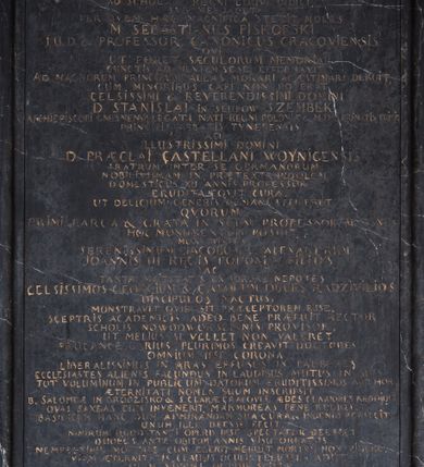 Zdjęcie nr 4: Epitafium w formie stojącego prostokąta wsparte na profilowanym gzymsie z konsolami i podwieszonym pod nim fartuchem z kartuszem z herbem Uniwersytetu Jagiellońskiego, ujęte pilastrami podtrzymującymi przełamujący się w kwadrat gzyms, zwieńczony falistym, przerwanym przyczółkiem z krzyżem pośrodku. Pilastry z kapitelami w formie maszkaronów, trzymających w ustach kiść girland owocowych są ujęte od zewnątrz spływami wolutowymi, od wewnątrz wydłużonymi wolutami. Pośrodku, w górnej wyłamanej części owalny portret zmarłego w kartuszu. Mężczyzna ukazany w popiersiu, z głową w trzech czwartych w prawo, z oczami zwróconymi prosto. Twarz malowana realistycznie, nos szeroki, długi, wargi zaciśnięte, oczy otwarte. Włosy jasne, krótkie, po bokach zaczesane do tyłu; tło nieokreślone, w tonacji brązu. Poniżej inskrypcja: &quot;D(EO) O(PTIMO) M(AXIMO) / LAPIDEM ME QVI TRANSIS VIATOR. / MUTUM NE EXISTIMA / EGO HUIUS QUAM CERNIS FABRICAE LINGVA / AD SCHOLAM REGNI LOQVI DIDICI. / SVB ME IACET. / PER QVEM HAEC MAGNIFICIA STETIT MOLES / M(AGISTER) SEBASTIANUS PISKORSKI / I(URIS) U(TRIUSQUE) D(OCTOR) ET PROFESSOR, CANONICUS CRACOVIENSIS / QVI / UT FORET / SAECULORUM MEMORIA / CUNCTIS AD MENTEM SESE EFFORMAVIT. / AD MAGNORUM PRINCIPUM AULAS MORARI AC AESTIMARI DEBUIT, / CUM MINORIBUS CAPI NON POTERAT / CELSISSIMI &amp; REVERENDISSIMI DOMINI / D(OMINI) STANISLAI IN  SŁUPOW SZEMBEK / ARCHIEPISCOPI GNESNESIS LEGATI NATI REGNI POLONIAE ET M(AGNI) D(UCATVI) L(ITHVANIAE) PRIMATIS / PRINCIPIS, ABBATIS TYNECENSIS / AC / ILLUSTRISSIMI DOMINI / D(OMINI) PRAECLAI CASTELLANI WOYNICENSIS / FRATRUM INTER SE GERMANORUM / NOBILISSIMAM IN PRAETEXTA INDOLEM / DOMESTICUS XII ANNIS PROFESSOR / ERUDITA FOVIT CURA, / UT DELICIUM GENERIS HUMANI EFFICERET / QVORUM / PRIMI LARGA ET GRATA IN SUUM PROFESSOREM MANUS / HOC MONUMENTUM POSUIT. / MOX POSTEA / SERENISSIMUM JACOBUM ET ALEXANDRUM / JOANNIS III REGIS POLONIAE FILIOS / AC / TANTAE MAIESTATIS EX SORORE NEPOTES / CELSISSIMOS GEORGIUM ET CAROLUM DUCES RADZIVILIOS / DISCIPULOS NATUS, / MONSTRAVIT QUID SIT PRAECEPTOREM ESSE. / SCEPTRIS ACADEMICIS ADEO BENE PRAEFUIT RECTOR / SCHOLIS NOWODWORSCIANIS PROVISOR, / UT MELIUS SI VELLET NON VALERET. / PROCANCELLARIUS PLURIMOS CREAVIT DOCTORES / OMNIUM IPSE CORONA / LIBERALISSIMUS IN ARAS EFFUSUS IN PAUPERES / ECCLESIASTES ALIENIS FACUNDUS IN LAUDIBUS MUTUS IN SUIS. / TOT VOLUMINUM IN PUBLICUM DATORUM ERUDITISSIMUS AUTHOR / AETERNITATI NOMEN SUUM INSCRIPSIT / B(EATAE) SALOMEAE IN GRODZISKO ET S(ANCTAE) CLARAE CRACOVIAE AEDES CLARIORES REDDIDIT / QUAS SAXEAS CUM INVENERIT, MARMOREAS PENE RELIQVIT. / BASILICAM HANC DUM ADMIRANDAM SUA CURA ET INGENIO PERFECIT / UNUM ILLI DEESE FECIT, NIMIRUM QUOD TANTI OPERIS IPSE SPECTATOR DEESSET / DUOBUS ANTE OBITUM ANNIS VISU ORBATUS, / NEMPE: NIHIL MORTALE CUM EGERIT MERUIT MORTEM NON VIDERE. / VIAM AETERNITATIS CLAUSIS OCULIS FELICITER ADIIT / QUAM VIVENS OPTIME SCIVIT / ANNO DOMINI MDCCVII DIE XVII AUGUSTI. / ABI VIATOR / ET NE DURIOR LAPIDE FIAS / A ME ELINGVI DISCE LOQVI / TANTNO VIRO / REQVIEM.&quot; 