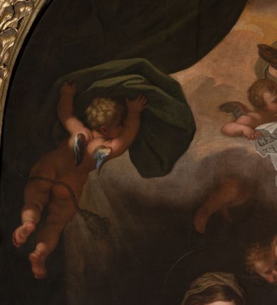 Zdjęcie nr 31: Obraz w kształcie stojącego prostokąta zamkniętego łukiem półkolistym, w złoconej ramie, ozdobionej wieńcem laurowym. W centrum kompozycji ukazana siedząca na fotelu Maria z Jezusem na kolanach i siedząca obok św. Anną w towarzystwie aniołów klęczących u ich stóp lub unoszących się w obłokach. Maria przedstawiona niemal frontalnie, przytrzymuje obiema rękami Jezusa siedzącego na jej lewym kolanie i pochyla głową lekko w lewo. Ubrana jest w różową, rozłożystą suknię i ciemnoniebieski płaszcz oraz brązową chustę na głowie. Jej twarz jest owalna, rysy łagodne, policzki lekko zaróżowione. Nos ma wąski i długi, oczy migdałowate, lekko przymknięte, usta wąskie, pełne, zaznaczone czerwienią. Widoczne spod chusty włosy są proste, opadają na plecy. Jezus siedzi frontalnie, z rozłożonymi nóżkami i rączkami, z których lewą trzyma i całuje św. Anna. Jego twarz jest pełna, policzki lekko zaokrąglone, nos krótki, oczy otwarte, a usta lekko rozwarte i uśmiechnięte, włosy na głowie krótkie, z kręconymi nieznacznie puklami. Dolną część podbrzusza i biodra okrywa biała pielucha. Anna jest ukazana niemal frontalnie, lekko pochylona w kierunku Marii i Jezusa, ubrana w zieloną suknię, czerwony płaszcz i białą chustę okrywającą głowę i szyję. Twarz wykazuje cechy starszej kobiety, z wyraźnymi zmarszczkami, z wyrazistym nosem, zamkniętymi oczami oraz ustami całującymi dłoń Jezusa. Na kolanach trzyma otwartą księgę. Po lewej stronie przy tronie klęczą na chmurach dwa nagie putta, o korpulentnych ciałach, kręconych włosach, z których jedno, na pierwszym planie jest zwrócone w kierunku głównych bohaterów, a drugie z tyłu patrzy na widza. W górnej części kompozycji, na obłoku unoszą się aniołowie, z których jeden, w prawej części kompozycji jest ukazany w całej postaci, w niebieskiej tunice i brązowym płaszczu, z rękami opuszczonymi ku dołowi i złożonymi w geście modlitwy, a głową ujętą z lewego profilu. Środkowy wychyla się zza chmury, okolony zieloną szatą, z lewą ręką złożoną na piersi. Trzeci anioł-putto trzyma pofalowaną kartkę z napisem: „GENERATIONEM EIUS QUIS ENARRABIT”. Po lewej stronie ukazany jest anioł podtrzymujący zieloną kotarę. Pod chmurą, tuż nad głową św. Anny, para uskrzydlonych główek anielskich. W prawej części kompozycji stolik na wolutowych nogach wspartych na lwich łapach i ozdobionych maszkaronami z koszem pełnym owoców oraz leżący na posadzce kosz wiklinowy z niewielką skrzynią i granatową tkaniną z białą podszewką.     

