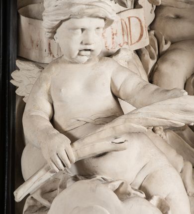 Zdjęcie nr 8: Na trójstopniowej podstawie osadzona prostopadłościenna mensa ołtarza ujęta lekko wybrzuszającymi się postumentami. Antepedium wykonane w technice marmoryzacji (skaliola) z owalnym polem pośrodku, z wyobrażeniem leżącego nagiego Dzieciątka Jezus z krzyżykiem w lewej dłoni i pierścieniem z krzyżem w prawej, pozostałe naroża wypełnione bukietami kwiatów. Na osi mensy nastawa w formie profilowanej ramy prostokątnej zamkniętej łukiem wklęsło-wypukłym, nadwieszonym, wypełnionej płaskorzeźbą z postacią św. Katarzyny. Święta ukazana w trzech czwartych, w pozycji klęczącej, na chmurach, z rękami złożonymi na piersi, z głową lekko odchyloną w głąb kompozycji. Jej twarz jest owalna, o pełnych policzkach, ze smukłym nosem, głębokimi oczodołami i otwartymi ustami. Na głowie włosy modelowane sumarycznie, długie, opadające na plecy oraz korona otwarta. Święta jest ubrana w długą suknię i obficie fałdowany płaszcz. Za jej plecami widoczny fragment koła – atrybutu jej męczeństwa, z przodu wyłaniające się płaskorzeźbione putta, z których jedno trzyma gałąź palmy. W górnej części kompozycji modelowane w płytkim reliefie chmury z widocznymi między nimi promieniami oraz uskrzydlone główki aniołków. Po bokach kolumny osadzone na bazach, ścięte w połowie wysokości ramy, zakończone skłębionymi obłokami chmur i siedzącymi na nich aniołkami. Lewy ukazany w pozycji półleżącej, z prawą ręką na piersi, a lewą wyciągniętą w kierunku osi ołtarza, z głową skierowaną w jego prawą stronę. Anioł po przeciwnej stronie siedzi na obłoku okrakiem i trzyma w ręku palmę męczeństwa. W tle obu aniołów płaskorzeźbione grupy puttów z banderolami z nieczytelnymi inskrypcjami. Nastawę wieńczy gloria promienista, której promienie wchodzą w partię okna, z siedzącą na obłokach postacią małego Jezusa z kulą ziemską przy boku i z prawą ręką uniesioną w geście błogosławieństwa, ubranego w rozwiany na plecach płaszcz. Kompozycję uzupełniają płaskorzeźbione grupy uskrzydlonych aniołków. Ołtarz z elementami czarnego i białego marmuru, barwnej marmoryzacji i białego, częściowo złoconego stiuku. 