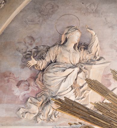 Zdjęcie nr 21: Zasadniczy ołtarz jest prostopadłościenny, z antepedium w technice skalioli, z owalnym polem, w którym znajduje się medalion obwiedziony kwiatami. Wydzielone wokół niego geometryczne pola pokryte są białą i czerwoną marmoryzacją. Za ołtarzem znajduje się monumentalna nastawa, składająca się z podwójnych cokołów, dwóch tylnych, ustawionych równolegle do prezbiterium, dwóch przednich ustawionych ukośnie, na których stoją osadzone na tle pilastrów kolumny o spiralnych trzonach. Po bokach kolumn unoszące się na chmurach uskrzydlone anioły w miękko modelowanych szatach. Trzony kolumn ozdobione wijącą się wokół nich wicią roślinną, ich kapitele w porządku kompozytowym podtrzymują belkowanie. Nad zewnętrznymi kolumnami unoszą się faliste naczółki, zaś nad wewnętrznymi siedzące anioły. Nad ołtarzem posadowiono dużych rozmiarów glorię promienistą z grupą aniołów i puttów. Pośrodku otwarta księga trzymana przez anioły z napisem: LIBER GENERATIONIS IESV CHRISTI. W polu środkowym nisza na obraz w kształcie prostokąta zamkniętego półkoliście, obwiedzionego rzeźbioną ramą z motywem liści lauru; na obrazie przedstawiona św. Anna Samotrzeć. Ołtarz flankują wsunięte do przodu figury św. Wojciecha i św. Stanisława, stojące na dostawionych do ścian bocznych prezbiterium cokołach, wybrzuszających się w górnej części. 