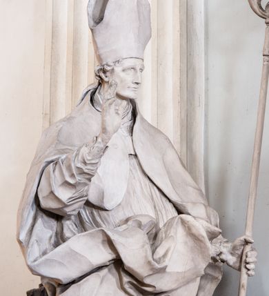 Zdjęcie nr 20: Zasadniczy ołtarz jest prostopadłościenny, z antepedium w technice skalioli, z owalnym polem, w którym znajduje się medalion obwiedziony kwiatami. Wydzielone wokół niego geometryczne pola pokryte są białą i czerwoną marmoryzacją. Za ołtarzem znajduje się monumentalna nastawa, składająca się z podwójnych cokołów, dwóch tylnych, ustawionych równolegle do prezbiterium, dwóch przednich ustawionych ukośnie, na których stoją osadzone na tle pilastrów kolumny o spiralnych trzonach. Po bokach kolumn unoszące się na chmurach uskrzydlone anioły w miękko modelowanych szatach. Trzony kolumn ozdobione wijącą się wokół nich wicią roślinną, ich kapitele w porządku kompozytowym podtrzymują belkowanie. Nad zewnętrznymi kolumnami unoszą się faliste naczółki, zaś nad wewnętrznymi siedzące anioły. Nad ołtarzem posadowiono dużych rozmiarów glorię promienistą z grupą aniołów i puttów. Pośrodku otwarta księga trzymana przez anioły z napisem: LIBER GENERATIONIS IESV CHRISTI. W polu środkowym nisza na obraz w kształcie prostokąta zamkniętego półkoliście, obwiedzionego rzeźbioną ramą z motywem liści lauru; na obrazie przedstawiona św. Anna Samotrzeć. Ołtarz flankują wsunięte do przodu figury św. Wojciecha i św. Stanisława, stojące na dostawionych do ścian bocznych prezbiterium cokołach, wybrzuszających się w górnej części. 