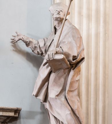 Zdjęcie nr 15: Zasadniczy ołtarz jest prostopadłościenny, z antepedium w technice skalioli, z owalnym polem, w którym znajduje się medalion obwiedziony kwiatami. Wydzielone wokół niego geometryczne pola pokryte są białą i czerwoną marmoryzacją. Za ołtarzem znajduje się monumentalna nastawa, składająca się z podwójnych cokołów, dwóch tylnych, ustawionych równolegle do prezbiterium, dwóch przednich ustawionych ukośnie, na których stoją osadzone na tle pilastrów kolumny o spiralnych trzonach. Po bokach kolumn unoszące się na chmurach uskrzydlone anioły w miękko modelowanych szatach. Trzony kolumn ozdobione wijącą się wokół nich wicią roślinną, ich kapitele w porządku kompozytowym podtrzymują belkowanie. Nad zewnętrznymi kolumnami unoszą się faliste naczółki, zaś nad wewnętrznymi siedzące anioły. Nad ołtarzem posadowiono dużych rozmiarów glorię promienistą z grupą aniołów i puttów. Pośrodku otwarta księga trzymana przez anioły z napisem: LIBER GENERATIONIS IESV CHRISTI. W polu środkowym nisza na obraz w kształcie prostokąta zamkniętego półkoliście, obwiedzionego rzeźbioną ramą z motywem liści lauru; na obrazie przedstawiona św. Anna Samotrzeć. Ołtarz flankują wsunięte do przodu figury św. Wojciecha i św. Stanisława, stojące na dostawionych do ścian bocznych prezbiterium cokołach, wybrzuszających się w górnej części. 