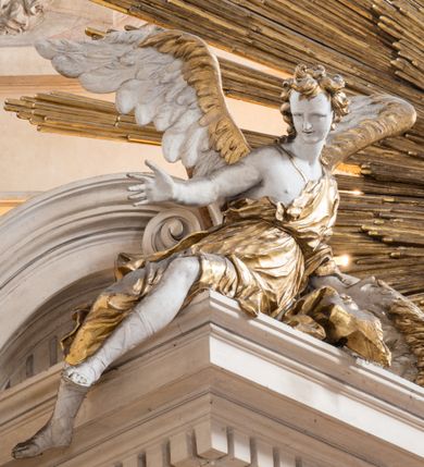 Zdjęcie nr 5: Zasadniczy ołtarz jest prostopadłościenny, z antepedium w technice skalioli, z owalnym polem, w którym znajduje się medalion obwiedziony kwiatami. Wydzielone wokół niego geometryczne pola pokryte są białą i czerwoną marmoryzacją. Za ołtarzem znajduje się monumentalna nastawa, składająca się z podwójnych cokołów, dwóch tylnych, ustawionych równolegle do prezbiterium, dwóch przednich ustawionych ukośnie, na których stoją osadzone na tle pilastrów kolumny o spiralnych trzonach. Po bokach kolumn unoszące się na chmurach uskrzydlone anioły w miękko modelowanych szatach. Trzony kolumn ozdobione wijącą się wokół nich wicią roślinną, ich kapitele w porządku kompozytowym podtrzymują belkowanie. Nad zewnętrznymi kolumnami unoszą się faliste naczółki, zaś nad wewnętrznymi siedzące anioły. Nad ołtarzem posadowiono dużych rozmiarów glorię promienistą z grupą aniołów i puttów. Pośrodku otwarta księga trzymana przez anioły z napisem: LIBER GENERATIONIS IESV CHRISTI. W polu środkowym nisza na obraz w kształcie prostokąta zamkniętego półkoliście, obwiedzionego rzeźbioną ramą z motywem liści lauru; na obrazie przedstawiona św. Anna Samotrzeć. Ołtarz flankują wsunięte do przodu figury św. Wojciecha i św. Stanisława, stojące na dostawionych do ścian bocznych prezbiterium cokołach, wybrzuszających się w górnej części. 