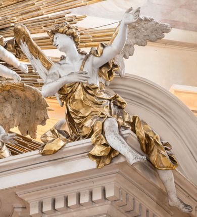 Zdjęcie nr 6: Zasadniczy ołtarz jest prostopadłościenny, z antepedium w technice skalioli, z owalnym polem, w którym znajduje się medalion obwiedziony kwiatami. Wydzielone wokół niego geometryczne pola pokryte są białą i czerwoną marmoryzacją. Za ołtarzem znajduje się monumentalna nastawa, składająca się z podwójnych cokołów, dwóch tylnych, ustawionych równolegle do prezbiterium, dwóch przednich ustawionych ukośnie, na których stoją osadzone na tle pilastrów kolumny o spiralnych trzonach. Po bokach kolumn unoszące się na chmurach uskrzydlone anioły w miękko modelowanych szatach. Trzony kolumn ozdobione wijącą się wokół nich wicią roślinną, ich kapitele w porządku kompozytowym podtrzymują belkowanie. Nad zewnętrznymi kolumnami unoszą się faliste naczółki, zaś nad wewnętrznymi siedzące anioły. Nad ołtarzem posadowiono dużych rozmiarów glorię promienistą z grupą aniołów i puttów. Pośrodku otwarta księga trzymana przez anioły z napisem: LIBER GENERATIONIS IESV CHRISTI. W polu środkowym nisza na obraz w kształcie prostokąta zamkniętego półkoliście, obwiedzionego rzeźbioną ramą z motywem liści lauru; na obrazie przedstawiona św. Anna Samotrzeć. Ołtarz flankują wsunięte do przodu figury św. Wojciecha i św. Stanisława, stojące na dostawionych do ścian bocznych prezbiterium cokołach, wybrzuszających się w górnej części. 