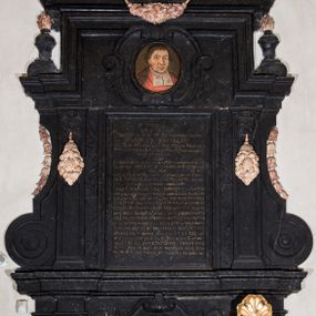 Zdjęcie nr 1: Epitafium w formie stojącego prostokąta wsparte na profilowanym gzymsie z konsolami i podwieszonym pod nim fartuchem z kartuszem z herbem Uniwersytetu Jagiellońskiego, ujęte pilastrami podtrzymującymi przełamujący się w kwadrat gzyms, zwieńczony falistym, przerwanym przyczółkiem z krzyżem pośrodku. Pilastry z kapitelami w formie maszkaronów, trzymających w ustach kiść girland owocowych są ujęte od zewnątrz spływami wolutowymi, od wewnątrz ulistnionymi wydłużonymi wolutami. Pośrodku, w górnej wyłamanej części owalny portret zmarłego w kartuszu "D(EO) O(PTIMO) M(AXIMO) PIIS MANIBUS / / PERILLUSTRIS OLIM ET REVERENDISSIMI DOMINI / M(AGISTRI) ANDREAE KRVPECKI / I(URIS) V(TRIUSQUE) D(OCTOR) ET P(HILOSOPHIAE) CANONICI CRACOVIENSIS PRAEPOSITI / PREMIICOVIENSIS SENIORIS PATRIS ET PROCANCELLARII / UNIVERSITATIS CRAC(OVIENSIS) / QUEM / CANDOR ANIMI AMABILEM ERUDITIO CONSPICUUM HONOR / ILLUSTREM VIRTUS ETIAM POST FATA SUPERSTITEM FECIT / HIC OLIM / IN CALVO MONTE. MOX IN LUBRANSCIANA ACADEMIA / PHI(LOSOPHI)AE PROFESSOR POSTEA DIRECTOR PARTEM SUI MELI/ORIS AEVI GLORIOSE CONSUMPSIT. / IUDEX CONSISTORII CRAC(OVIENSIS) SURROGATUS IUSTITIAM IN/ TEMERATE COLUIT, STUDII GENERALIS ALMAE UNI/VERSITATIS CRAC(OVIENSIS) DIFFICILIMO TEMPORE SEXDECI/ES RECTOR PRO IURIBUS EIUS INDEFESSUS CERTAVIT / COLLEGII IURIDICI INSIGNIS BENEFACTOR SED MAXIME HUIUS BASILICAE QUAM CUPRO INGENTI SU(M)PTU / PENE TOTAM TEXIT ARGENTEA SUPELLECTILI PRETIOSE / ORNAVIT IPSE MORIBUS COMITATE ET VITA ORNATISSIMUS / TANDEM DIERUM ET MERITORUM PLENUS CHRI/STIANE OBIIT ANNO SALUTIS 1.  7. 25 DIE 25 / APRILIS AETATIS SUAE 82. IN ECCLESIA CATHE/DRALIS CRACO(OVIENSIS) EXPECTAT. DONEC VENIAT IMMU/TATIO SUA IN HAC EIUS MEMORIAE HOC MONU/MENTUM EXECUTORES TESTAMENTI POSUERUNT".