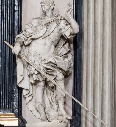 Zdjęcie nr 9: Ołtarz ustawiony na trójstopniowym podeście, prostopadłościenny, z antepedium z dekoracją w technice skaliola z pól geometrycznych dzielonych listwami i wypełniony drobnymi, wielobarwnymi kwiatkami. Za ołtarzem monumentalna nastawa utworzona z pilastrów i ukośnie ustawionych filarów stojących na wysokich postumentach. Ich trzony są kanelowane, a kapitele utworzone z jońskich wolut i przewiązanych taśmą lilijek. Nad kapitelami wznosi się belkowanie, nad zewnętrznymi pilastrami zwieńczone falistymi naczółkami, nad wewnętrznymi grupami uskrzydlonych puttów. Pośrodku znajduje się prostokątna wnęka zakończona łukiem półkolistym, nadwieszonym, w profilowanej ramie. W niej stiukowy relief przedstawiający Chwałę Krzyża Świętego adorowanego przez Matkę Boską z martwym Chrystusem spoczywającym na jej kolanach oraz przez św. Jana Ewangelistę odwróconego do widza plecami. Maria ukazana frontalnie, ubrana w rozłożystą suknię i  płaszcz zarzucony na głowę, z prawą ręką dotykająca głowy Jezusa, z lewą wyciągniętą do przodu. Jan przedstawiony w wykroku, z rękami wysuniętymi przed siebie, ubrany w suknię i płaszcz odkrywający lewy bark. Za Chrystusem ukazany anioł trzymający jego rękę. Nad nimi grupa aniołów unoszących krzyż. Ponad wnęką widnieje promienista, złocona gloria, z postacią Boga Ojca zasiadającego w chmurach, z gołębicą Ducha Świętego, puttami i główkami aniołów. Po bokach stoją figury św. Weroniki i św. Longina. Święta jest ubrana w długą, ekspresyjnie marszczoną suknię, w rękach trzyma rozłożoną chustę z twarzą Chrystusa. Longin jest przestawiony w zbroi rzymskiego legionisty, z długim, efektownie formowanym płaszczem, z lanca w prawej dłoni. 
