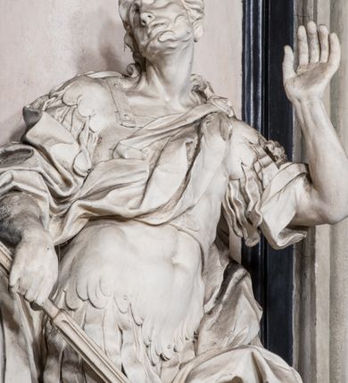 Zdjęcie nr 10: Ołtarz ustawiony na trójstopniowym podeście, prostopadłościenny, z antepedium z dekoracją w technice skaliola z pól geometrycznych dzielonych listwami i wypełniony drobnymi, wielobarwnymi kwiatkami. Za ołtarzem monumentalna nastawa utworzona z pilastrów i ukośnie ustawionych filarów stojących na wysokich postumentach. Ich trzony są kanelowane, a kapitele utworzone z jońskich wolut i przewiązanych taśmą lilijek. Nad kapitelami wznosi się belkowanie, nad zewnętrznymi pilastrami zwieńczone falistymi naczółkami, nad wewnętrznymi grupami uskrzydlonych puttów. Pośrodku znajduje się prostokątna wnęka zakończona łukiem półkolistym, nadwieszonym, w profilowanej ramie. W niej stiukowy relief przedstawiający Chwałę Krzyża Świętego adorowanego przez Matkę Boską z martwym Chrystusem spoczywającym na jej kolanach oraz przez św. Jana Ewangelistę odwróconego do widza plecami. Maria ukazana frontalnie, ubrana w rozłożystą suknię i  płaszcz zarzucony na głowę, z prawą ręką dotykająca głowy Jezusa, z lewą wyciągniętą do przodu. Jan przedstawiony w wykroku, z rękami wysuniętymi przed siebie, ubrany w suknię i płaszcz odkrywający lewy bark. Za Chrystusem ukazany anioł trzymający jego rękę. Nad nimi grupa aniołów unoszących krzyż. Ponad wnęką widnieje promienista, złocona gloria, z postacią Boga Ojca zasiadającego w chmurach, z gołębicą Ducha Świętego, puttami i główkami aniołów. Po bokach stoją figury św. Weroniki i św. Longina. Święta jest ubrana w długą, ekspresyjnie marszczoną suknię, w rękach trzyma rozłożoną chustę z twarzą Chrystusa. Longin jest przestawiony w zbroi rzymskiego legionisty, z długim, efektownie formowanym płaszczem, z lanca w prawej dłoni. 
