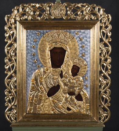 Zdjęcie nr 3: Feretron w typie obrazowym osadzony na niewysokiej, profilowanej podstawie z parą otworów na drążki. Pola obrazowe w kształcie stojących prostokątów ujmuje dekoracyjna, profilowana, złocona rama z rzeźbionym, ażurowym motywem ulistnionej wici, zwieńczona okrągłym medalionem z monogramem chrystologicznym na awersie i maryjnym na rewersie. Awers feretronu zajmuje półpostaciowy wizerunek Jezusa w typie Ecce Homo. Jezus zwrócony jest niemal na wprost. Przechyloną, zwróconą nieznacznie w trzech czwartych w prawo głowę charakteryzuje pociągła twarz o delikatnych rysach, długim nosie i krótkim, brązowym zaroście. Długie, falowane włosy opadają na barki. Głowę wieńczy cierniowa korona i okala promienisty nimb. Na twarzy, szyi i barkach widoczne są drobne stróżki krwi. Nagą klatkę piersiową Jezusa charakteryzuje rytmiczny układ żeber. Skrzyżowane na wysokości talii, zgięte w łokciach ręce związane są w nadgarstkach sznurem, w lewej dłoni trzyma pojedynczą trzcinę. Na ramiona Jezusa narzucony jest osłaniający biodra płaszcz zdobiony aplikacjami w formie rozetek na krótkich, ulistnionych łodyżkach. Elementy takie jak nimb, korona cierniowa, sznur, trzcina i płaszcz są płaskorzeźbione i złocone. Tło utrzymane jest w odcieniu szafiru. 
Rewers feretronu stanowi wizerunek Matki Boskiej Częstochowskiej. Ukazana półpostaciowo, zwrócona frontalnie Maria ma nieznacznie w trzech czwartych w lewo skierowaną głowę. Pociągłą, owalną twarz charakteryzują linearnie opracowane rysy o nieco przymkniętych oczach, długim prostym nosie i niewielkich ustach. Na prawym policzku widoczne dwie ukośne linie blizn. Maria ubrana jest w suknię i osłaniający jej głowę i sylwetkę płaszcz zdobiony aplikacjami w formie rozetek na krótkich, ulistnionych łodyżkach. Pod szyją są trzy sznury korali i krzyż. Prawą, uniesioną na wysokości klatki piersiowej dłonią o wyprostowanych palcach, wskazuje na siedzące na jej lewej ręce Dzieciątko, zwrócone w trzech czwartych w prawo. Okrągłą twarz Jezusa charakteryzują rysy dorosłego człowieka, o podobnym do Marii typie fizjonomii. Ubrany jest w długą suknię o trójkątnym dekolcie, zdobioną aplikacjami w formie rozetek. Prawą rękę unosi w geście błogosławieństwa, lewą ujmuje trzymaną na kolanach zamkniętą księgę. Karnacje postaci są ciemne, a ich głowy wieńczą korony w typie otwartym, okalają nimby z wpisanymi w nie promieniami oraz wieniec 12 gwiazd. Szaty, korony, nimby, gwiazdy i księga są płaskorzeźbione, złocone i srebrzone. Tło jest srebrzone. 
